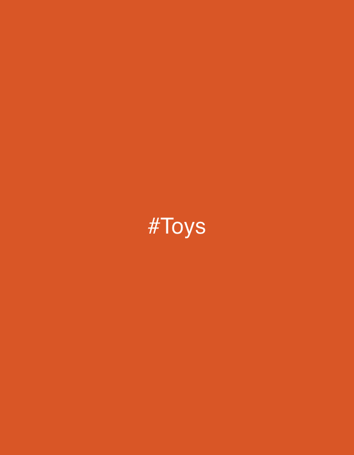 The image displays a solid, uniform orange background. Centrally positioned within this orange field is the white text '#Toys', rendered in a sans-serif typeface. No people, specific subjects, objects beyond the text, actions, or interactions are present within the visual frame. The environment is entirely abstract, defined solely by the orange color field. No topographical features, architectural elements, or other visual cues are depicted that would identify a specific location within the city of Leganés, Spain.