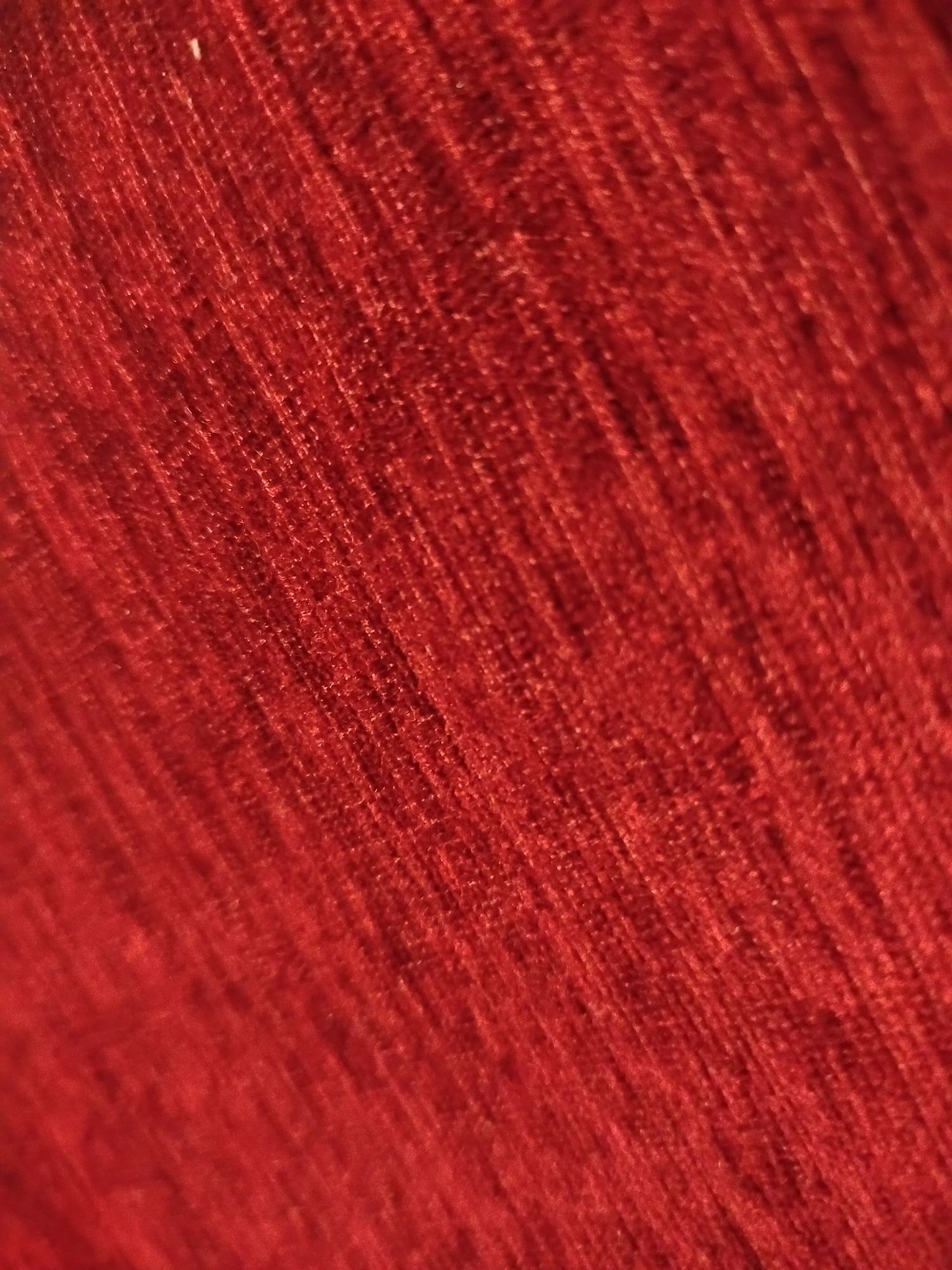 The image shows a close-up of a textured, red fabric. The fabric appears to be woven or knitted, with distinct lines and patterns. The image is dominated by the color red, with variations in tone due to lighting and texture. There are no people or other objects visible in the image.
There is no information available in the image to associate this fabric with Yerevan, Armenia.