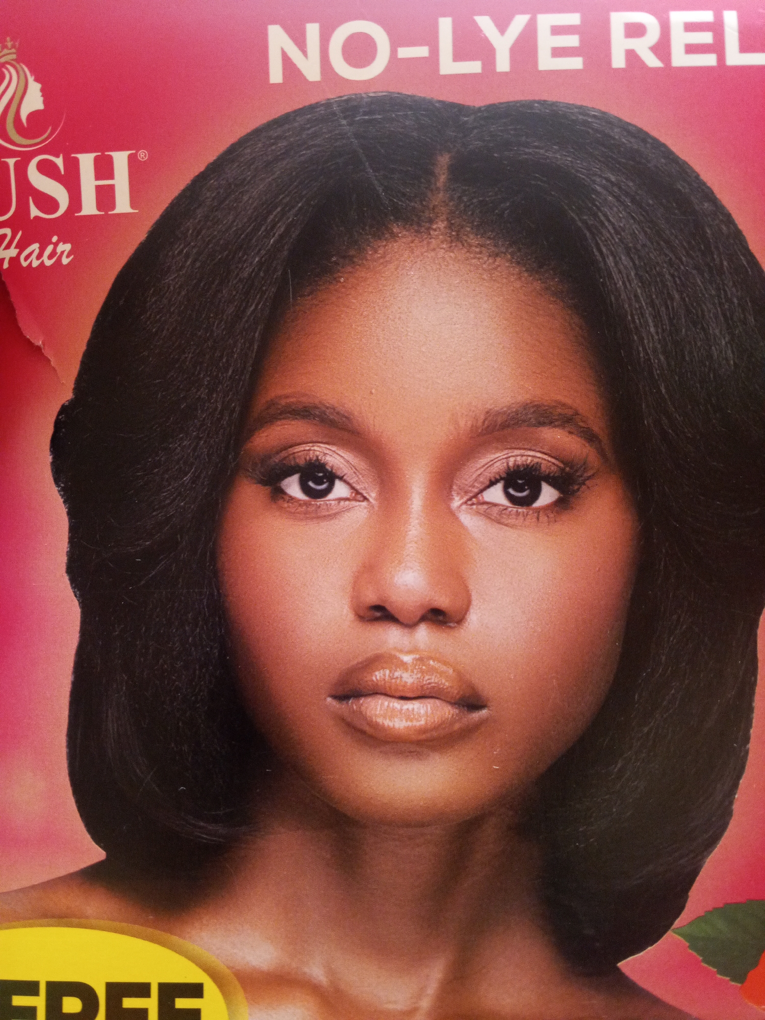 The image shows a close-up of a Black woman with dark brown hair styled in a shoulder-length bob with a middle part. She has a light brown complexion, dark eyes with long lashes, and full, glossy lips. She is looking directly at the camera with a neutral expression. The background is pink with white text that reads "NO-LYE REL" in the top right corner, "USH Hair" in the top left corner, and "FREE" at the bottom. The image appears to be a promotional advertisement for a hair product. There is no information in the image about Gwong, Nigeria.