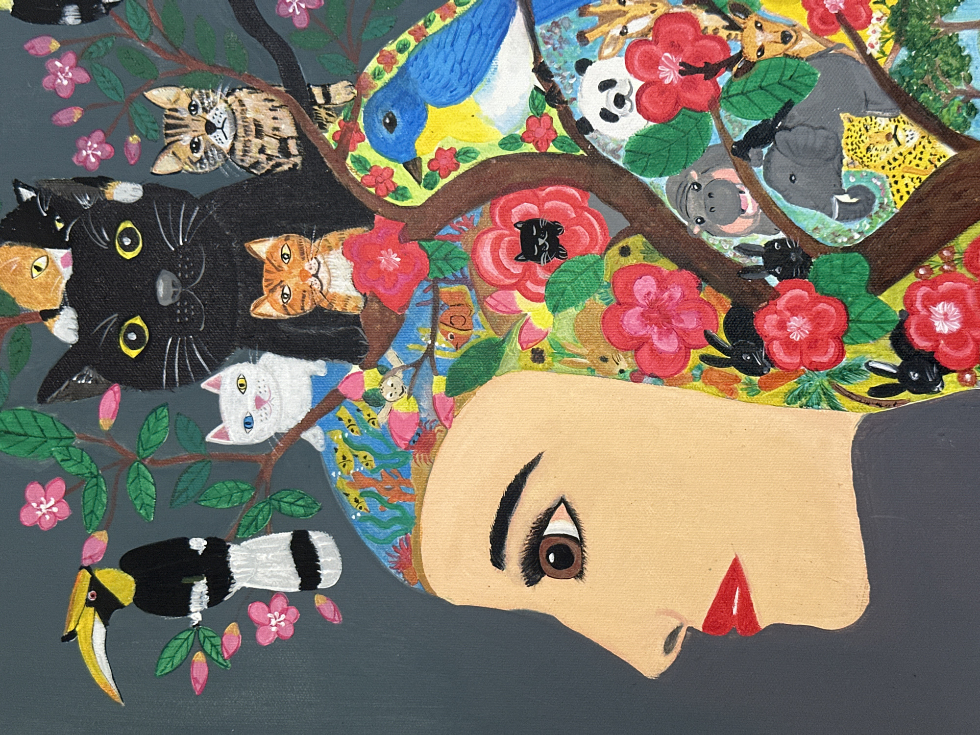 The image is a painting of a woman's profile with her hair depicted as a surreal landscape filled with animals, flowers, and trees. The woman has fair skin, a dark eyebrow, a brown eye, a small nose, and red lips. Her hair contains various cats (tabby, black, orange, white), a bluebird, a panda, a giraffe, a hippopotamus, an elephant, a leopard, black rabbits, red flowers, and tree branches. A hornbill bird is perched on a flowering branch near the woman's head. The background is a flat gray color. The image does not contain location information beyond being an image.