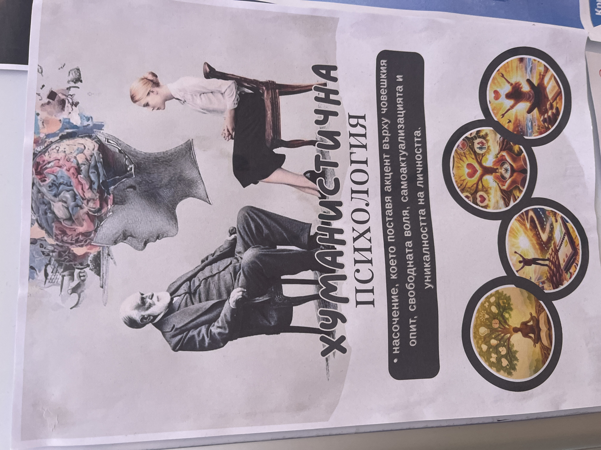 The image shows a poster featuring a collage design. The collage includes:
* A gray-scale portrait of a man in a suit, lying back.
* A female figure in a white blouse and dark skirt, with part of a chair connecting her legs and the man.
* A stylized head with an open brain containing colorful abstract elements.
* Several circular vignettes with various images depicting human figures in different settings related to personal growth and relationships, positioned on the right side of the poster.
* The words "ХУМАНИСТИЧНА ПСИХОЛОГИЯ" ("Humanistic Psychology") in bold, rotated text.
* A bullet-point description in Bulgarian, referencing the focus on human experience, free will, self-actualization, and the uniqueness of the individual.
The photograph was taken indoors, showing the poster partially against a white wall.
I cannot confirm if the location is in the city of Zlatograd, Bulgaria without additional information.