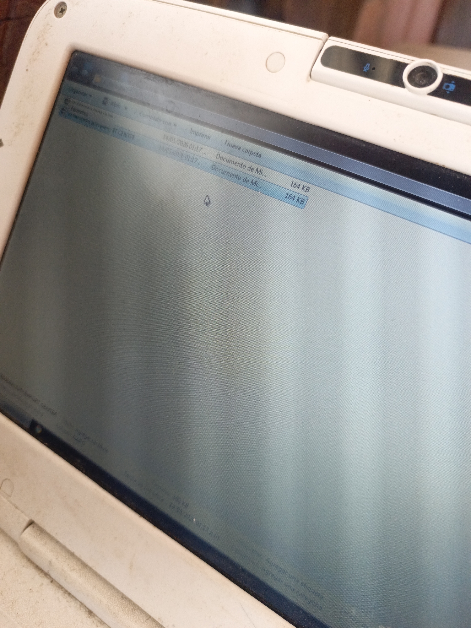 The image shows a close-up view of a white laptop screen. On the screen, a file explorer window is open, displaying a list of files. Two files named "Documento de Mi..." are listed, both with a size of 164 KB and a date of 14/05/2026 01:17 and 14/05/2025 01:17 respectively. The laptop's camera is visible at the top of the screen. The surrounding frame of the laptop shows signs of wear and dust. There is no information in the image regarding the city of Juan Griego, Venezuela.
