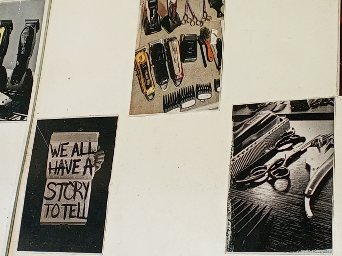 The scene depicts a light-colored interior wall in the city of Gwong, Nigeria, serving as a display surface for four affixed photographic prints or posters. The top-left, top-middle, and bottom-right prints feature a collection of professional barbering equipment. These items include multiple electric hair clippers (one identifiable as "Wahl Magic Clip," others as "Wahl"), various scissors, combs, straight razors, a brush, and an assortment of clipper guards, arranged on a flat surface. The top-middle print is in color, while the others are grayscale. The bottom-left print is a grayscale graphic depicting an open book held by a visible hand, with the handwritten text "WE ALL HAVE A STORY TO TELL" inscribed across its pages. No people are actively depicted, and no interactions are occurring within the frame.