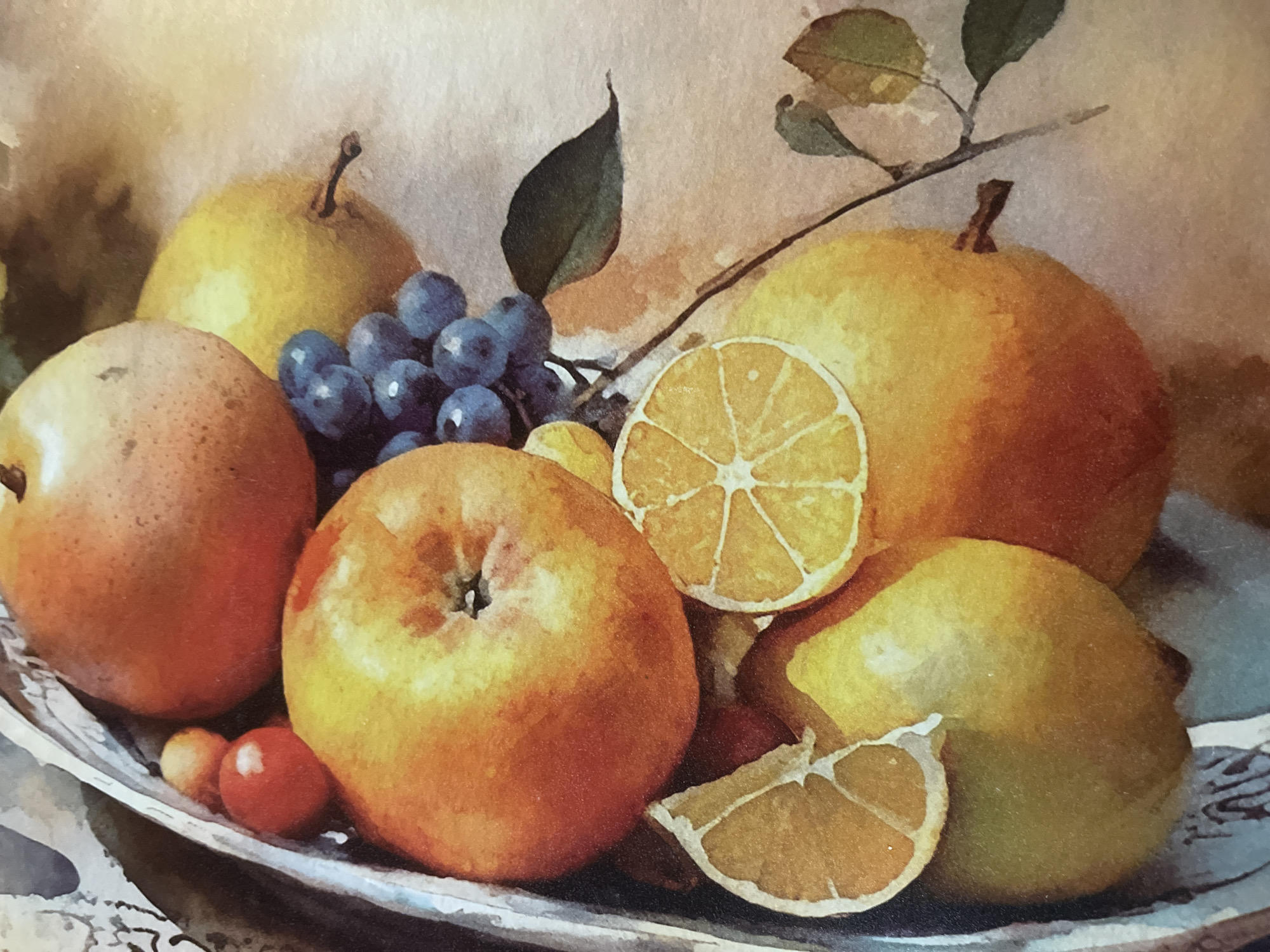 This is a close-up, top-down watercolor painting of a fruit still life. The arrangement features several fruits including apples, pears, grapes, lemons, and what appear to be small red berries or cherries. The fruits are clustered together, with some partially obscured by others. Two slices of lemon are prominently displayed, revealing their segmented interiors. The painting is rendered in warm tones of orange, yellow, red, and blue, with soft, blended brushstrokes characteristic of watercolor. The background is a mottled, warm beige color, suggesting a neutral surface. There is no visible indication of a specific location in the city of Minsk, Belarus, as the scene is an artistic composition.