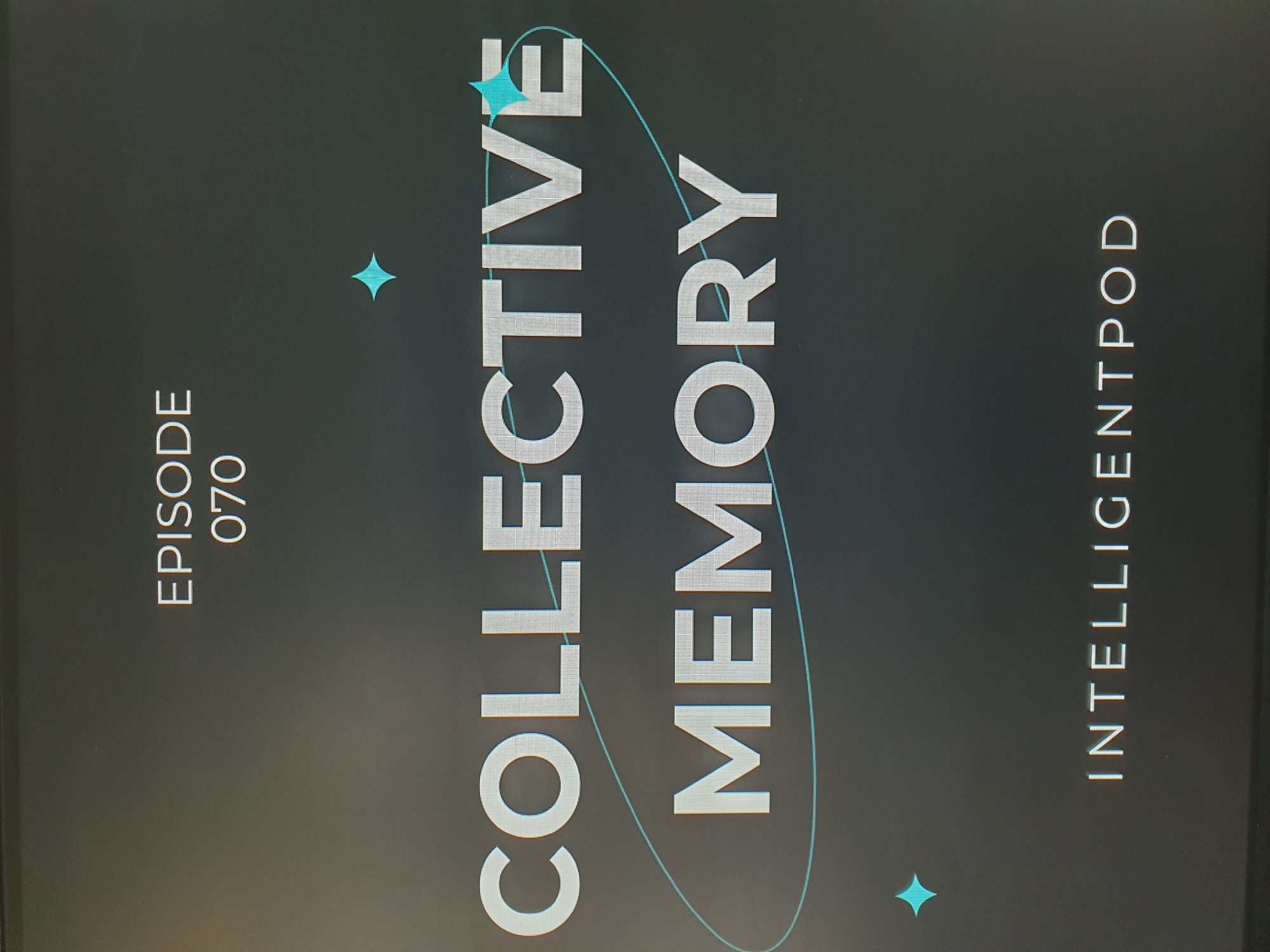 The image is a screenshot of a digital display showing text on a dark gray background. The text at the top reads "EPISODE 070". Below that, in larger font, are the words "COLLECTIVE MEMORY", with "COLLECTIVE" on the first line and "MEMORY" on the second. A thin, light blue elliptical line encircles the words "COLLECTIVE MEMORY". Two small, light blue star-like shapes are visible above and to the left and right of the words. At the bottom of the display, centered, is the text "INTELLIGENTPOD". There is no information in the image that would allow for identification of its location in Tashkent, Uzbekistan. The image depicts a graphic design for what appears to be a podcast or episode title.