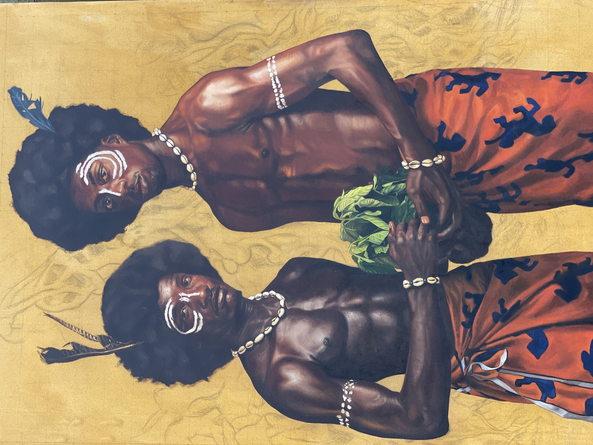 This is a painting of two men in traditional attire, standing in front of a gold-colored background. The man on the left has a dark, curly afro with a feather and a black bird feather in it. He has white face paint on his forehead and cheeks, in a circular pattern around his eyes. He is wearing a necklace made of shells and a red and blue patterned wrap around his waist. He has shell bracelets on both wrists. The man on the right also has a dark, curly afro, with a blue feather on top. He has similar white face paint on his forehead and cheeks. He is wearing a shell necklace and a red and blue patterned wrap around his waist. He has a shell bracelet on his right wrist. He is holding a bunch of green leaves in his hands. The background is textured gold with faint sketched outlines of figures and objects. The painting is rendered with realistic detail, highlighting the musculature of the men and the texture of their skin, hair, and clothing. There is no specific indication of the city of Ado, Nigeria, within the image itself.