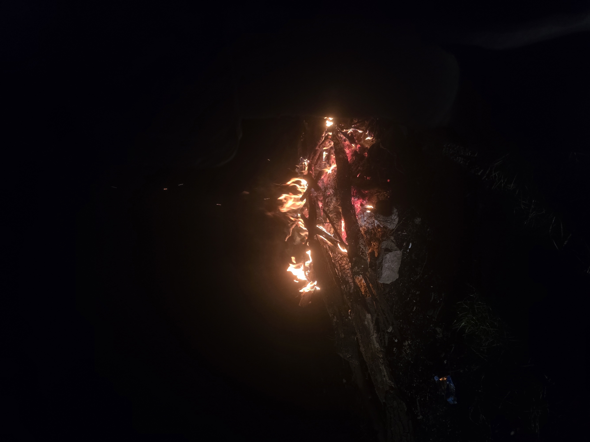 A fire burns in the darkness, possibly on a tree. It is not possible to determine the location in Yambol, Bulgaria from this image. There are no people visible.