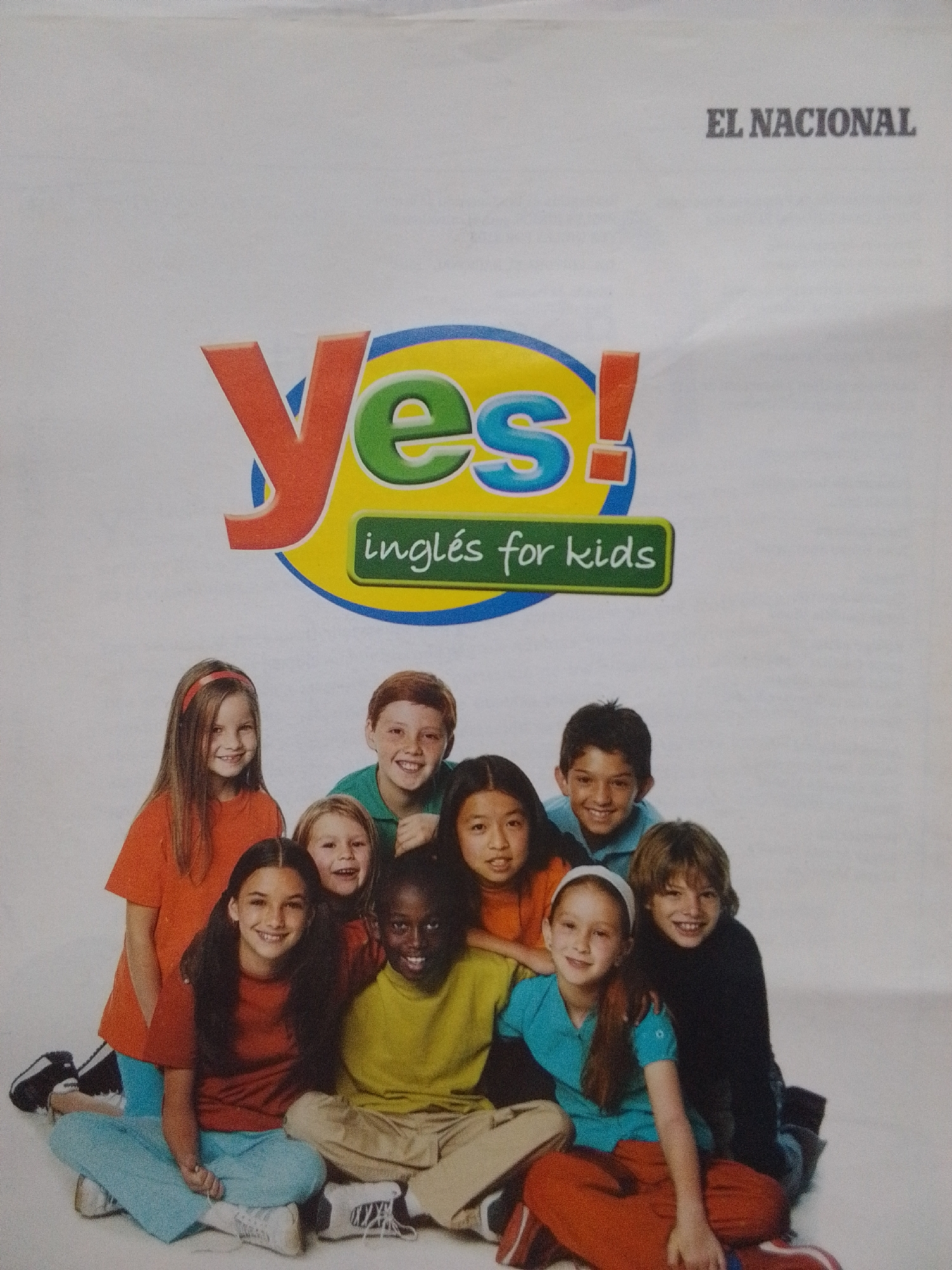 A group of ten children, appearing to be of elementary school age, are posed in front of a white background. The children are arranged in two rows, with some sitting on the floor and others standing behind them. They are all smiling and looking towards the camera. The children are ethnically diverse, with varying hair and skin tones. They are dressed in casual clothing, including t-shirts, sweaters, and pants.
Above the children, a large logo with the word "Yes!" in bold, colorful letters is displayed. Below the logo, a green banner reads "inglés for kids". In the upper right corner of the image, the words "EL NACIONAL" are printed in grey text.
The image appears to be a promotional photograph for an English language learning program for children, possibly associated with the publication "El Nacional." There is no visible information within the image that indicates a specific location in La Tagua, Venezuela.