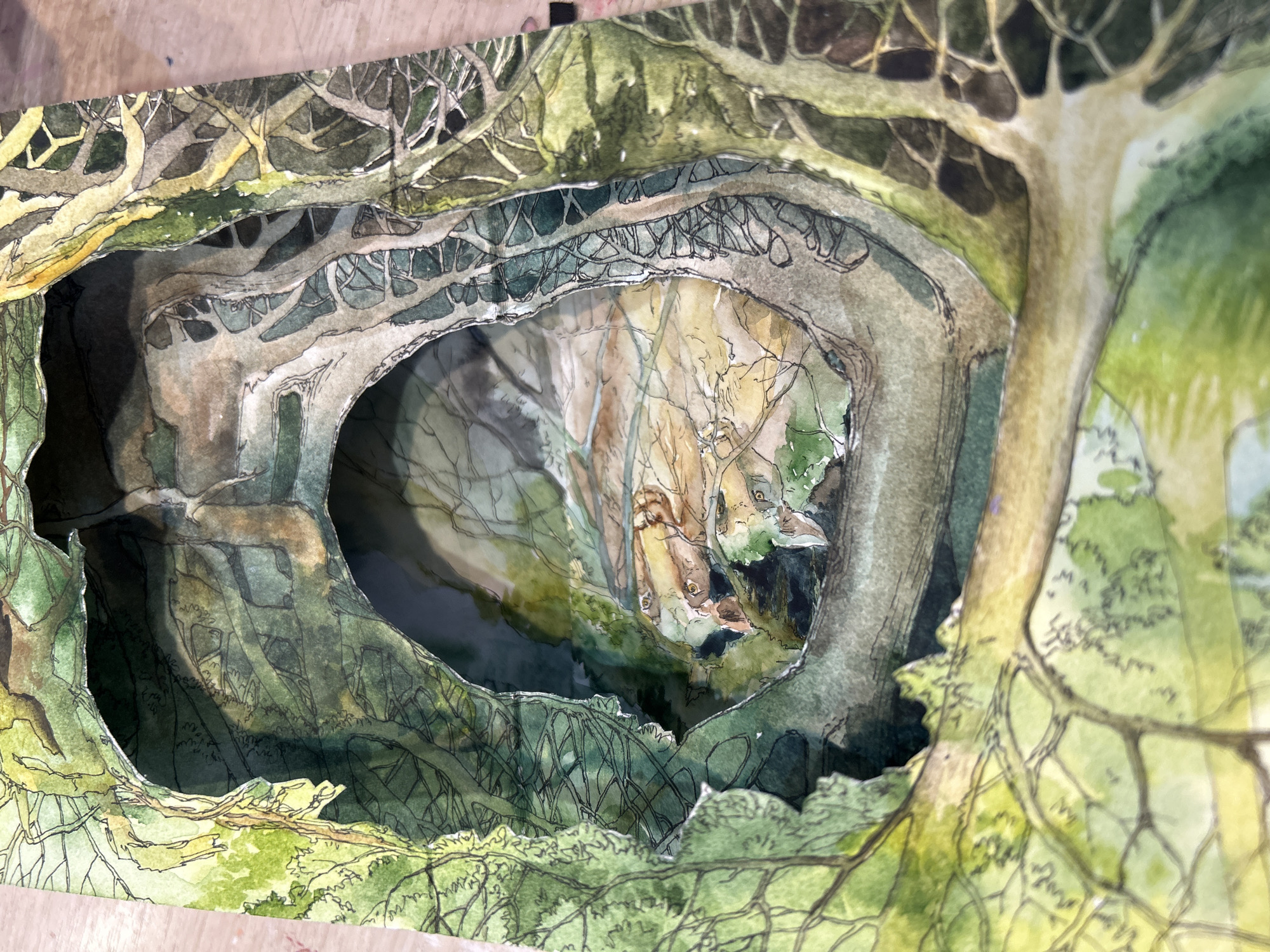 This intricate multi-layered artwork, originating from Izhevsk, Russia, presents a captivating forest scene, meticulously crafted as a three-dimensional diorama. The primary subjects are gnarled trees, intertwining roots, and dense foliage, all rendered in a distinct illustrative style using watercolor washes and prominent black ink outlines.
The artwork features several cut-out layers of painted paper, ingeniously arranged to create significant physical depth. These layers recede into the background, forming a tunnel-like opening that draws the viewer's eye deeper into the forest's hidden recesses. The foreground layers display lush green leaves and robust tree trunks, while subsequent layers depict increasingly tangled branches and roots, casting shadows and enhancing the sense of a dense, ancient wood.
The color palette is dominated by various shades of green and earthy browns, with hints of muted yellow suggesting dappled sunlight. The watercolor technique lends a soft, natural quality to the foliage and tree bark, contrasting with the sharp, graphic outlines of the ink. Within the deepest part of the tunnel, faint, abstract shapes emerge from the shadows. These forms, particularly visible in the central depth, appear to be suggestive of watchful eyes or animal-like faces, adding an element of mystery and wonder to the hidden space.
There is no discernible human activity depicted, nor any visible text on the artwork. The scene evokes a sense of enchantment and secret discovery, characteristic of fantasy or fairytale illustrations. The overall impression is one of a magical, secluded natural sanctuary, inviting exploration into its shadowed depths, seemingly observed during daytime under natural light.