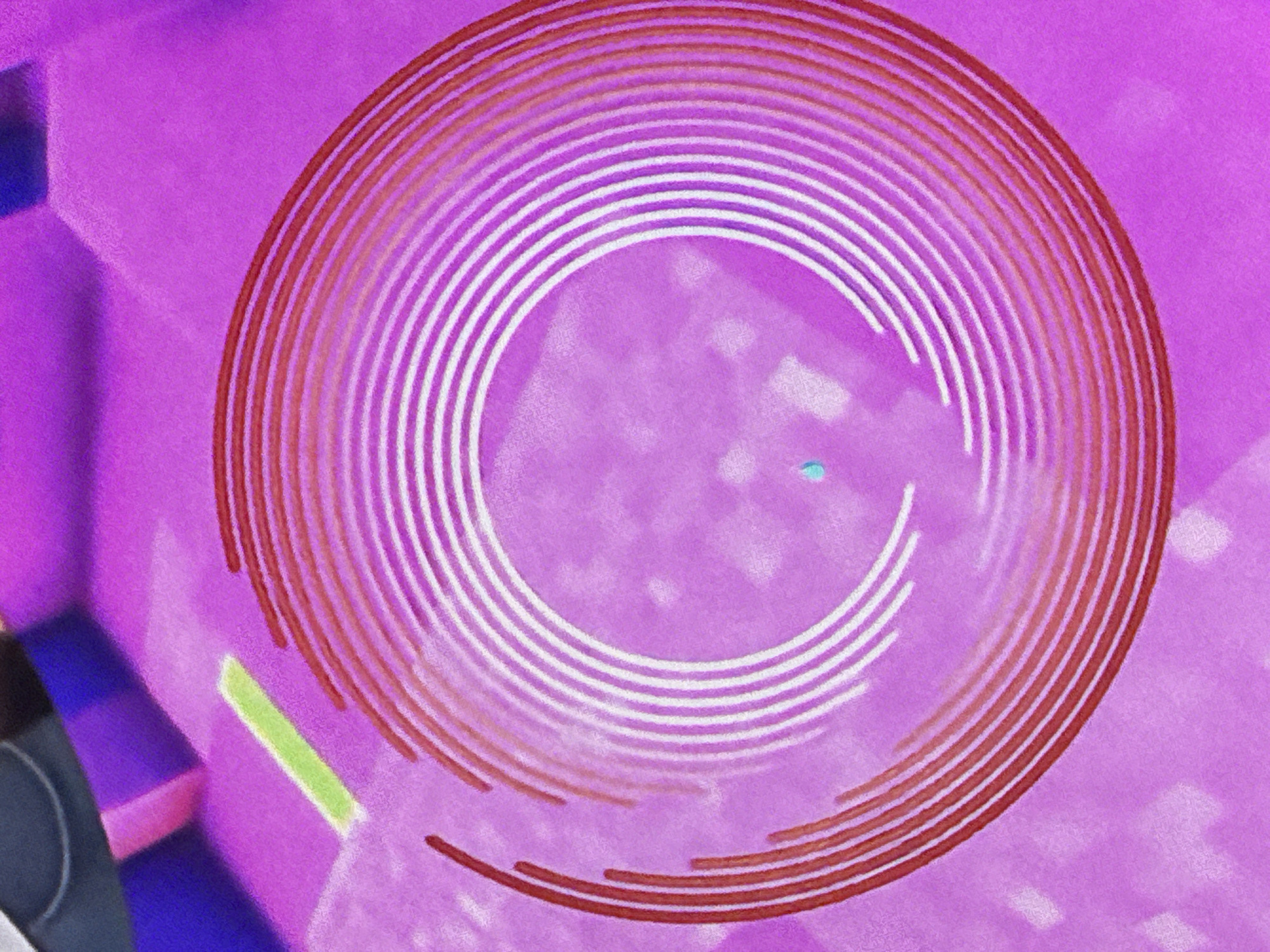 The image shows a close-up, abstract depiction of a spiral pattern composed of red and white lines against a vibrant purple background. There are also hints of other colors and shapes in the background, suggesting a larger, possibly synthetic, environment. There is no discernible location in Saratov, Russia, or any context that could be associated with it. The image appears to be a digital rendering or a stylized photograph with no clear narrative or identifying features.