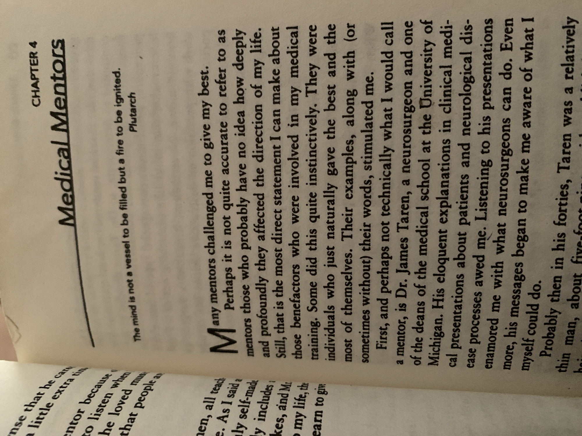 The image is a close-up photograph of an open book, taken from a slightly elevated angle. The book is open to chapter four, titled "Medical Mentors." A quote from Plutarch, "The mind is not a vessel to be filled but a fire to be ignited," is printed below the chapter title. The main body of the text discusses the author's experiences with mentors, particularly a neurosurgeon named Dr. James Taren. The left page of the book contains text that is partially cut off by the image border, including phrases like "nse that he care," "a little extra tim," "mentor because," "to listen when," "he loved mus," and "that people an." The right page contains the chapter title, quote, and the beginning of the narrative. The lighting suggests an indoor setting, possibly a well-lit room, and the pages of the book appear to be slightly aged with a cream-colored hue. There are no people, objects, or environmental details present in the image that would suggest a location in the city of Jos, Nigeria.