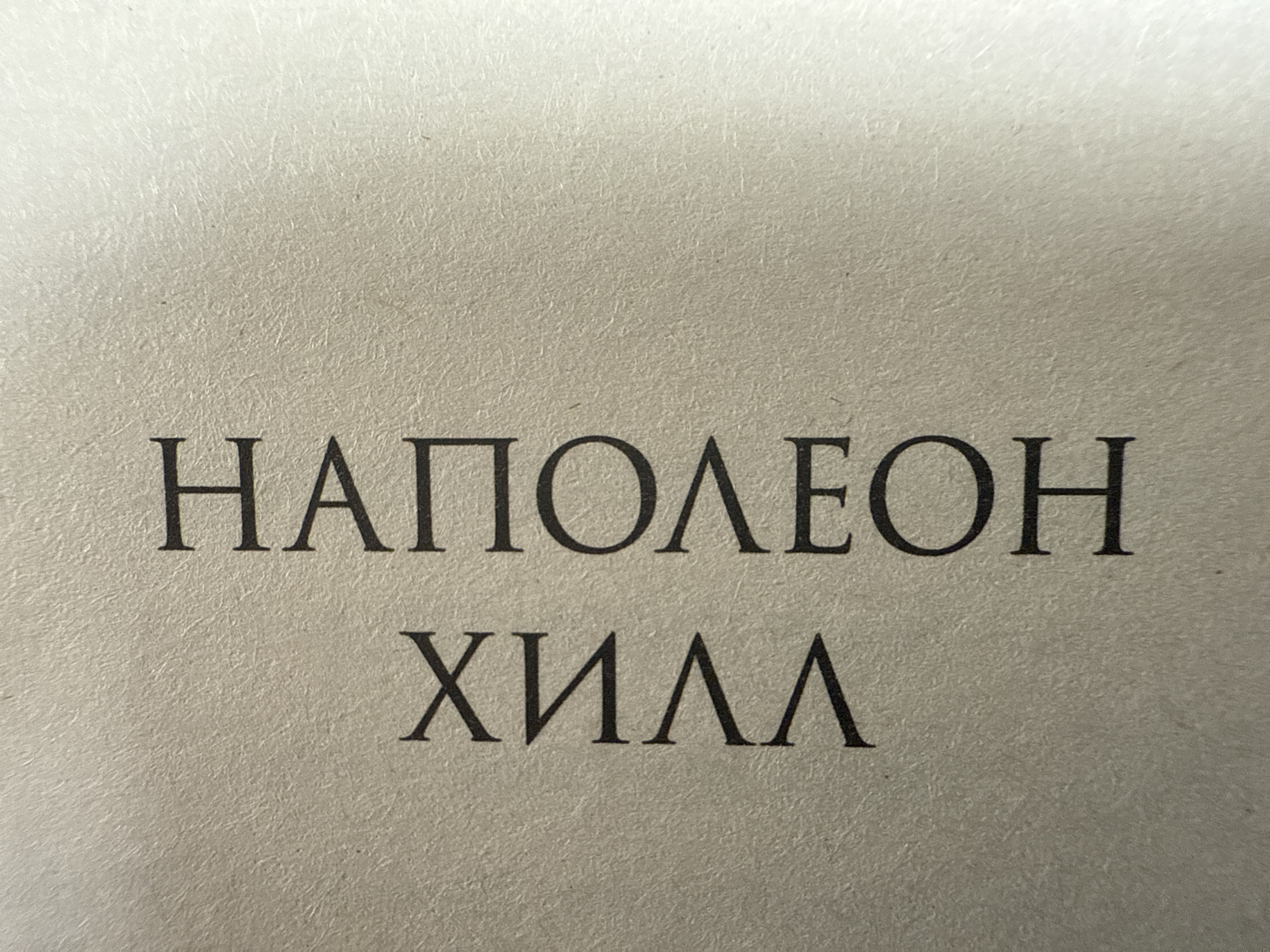 The image shows the name "НАПОЛЕОН" and "ХИЛЛ" printed in a dark serif font on a textured, light gray or beige background. The names are stacked, with "НАПОЛЕОН" on top of "ХИЛЛ." The location is unknown.
