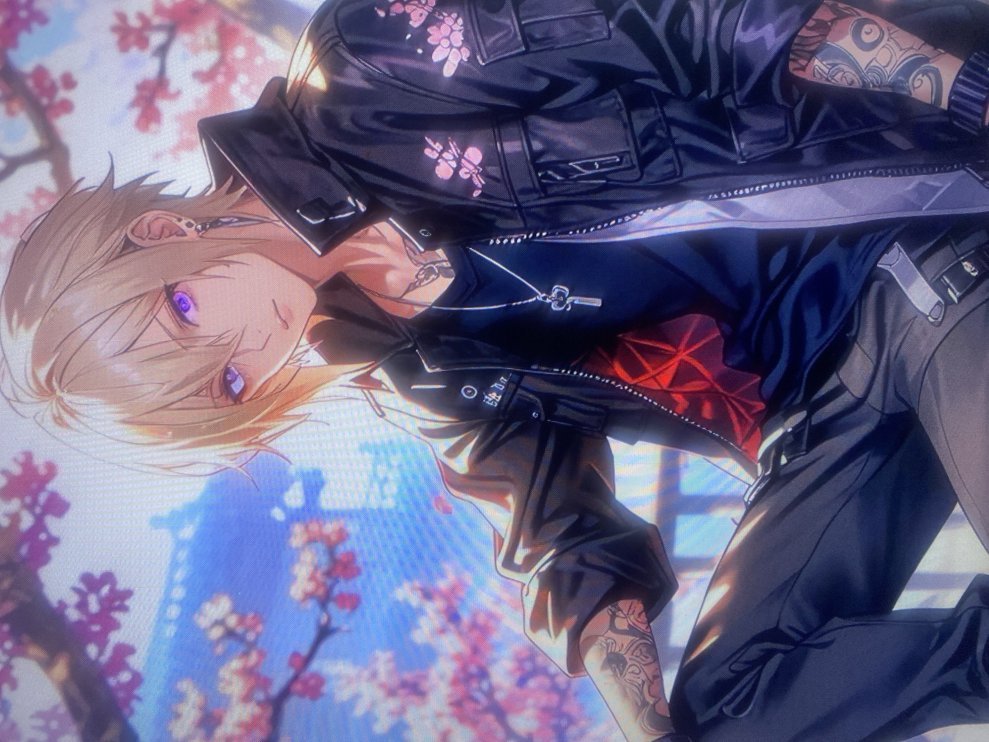 The image is a digital illustration of an anime-style young man with blonde hair and purple eyes. He is wearing a black leather jacket with pink cherry blossom designs, a dark t-shirt with a red geometric pattern visible beneath, dark pants, and a silver key-shaped necklace. He has tattoos on his arms. The background features a blurry depiction of cherry blossom branches and a traditional-looking building with a blue roof, set against a bright sky. There is no indication of the city of Samara, Russia in this image.