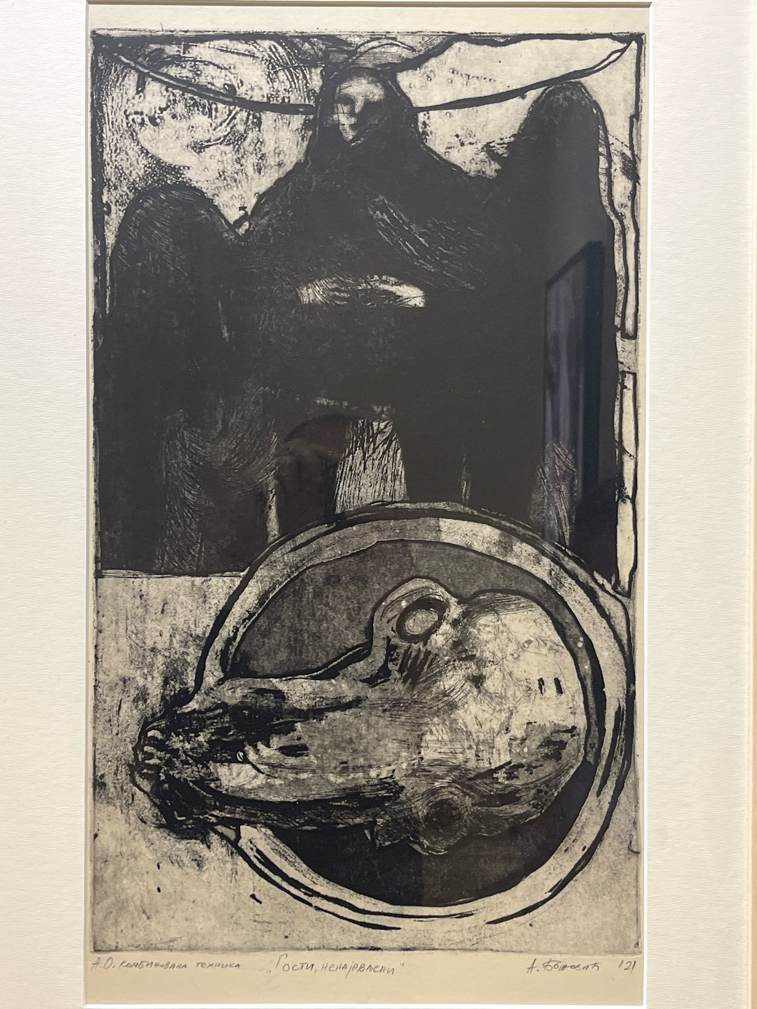 This is a black and white etching, framed and matted, depicting a surreal and possibly disturbing scene. The upper portion of the artwork features a dark, imposing figure with what appear to be wings or draped cloth. The figure has a vague face with dark eyes. Below this, a large, oval shape encloses a detailed rendering of a head or mask with prominent features, including an eye socket and what resembles a snout or nose. The style is rough and expressive, with heavy use of line and texture to create a sense of depth and shadow.
The bottom of the artwork includes text in what appears to be Cyrillic script. To the left, it reads "4.0. комбинована техника", which translates to "4.0. combined technique". To the right of this, in quotation marks, is "„Гости, ненајављени“", meaning "„Unannounced Guests“". Further to the right, there is a signature that appears to be "А. Божовић" and the number "121".
This artwork is located in the National Museum of Montenegro, in Cetinje, Montenegro. However, the question asks for the location in Podgorica, Montenegro. Without additional context or information about where this specific artwork is displayed in Podgorica, its precise location within the city cannot be determined.