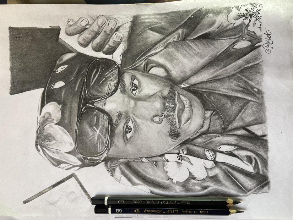 This image features a detailed, monochrome pencil drawing of an individual, originating from Jos, Nigeria. The drawing depicts a person with dark skin tone, looking directly at the viewer with a subtle smile. The subject wears a floral-patterned headwrap and dark, rectangular sunglasses pushed up on the forehead, allowing the eyes to be visible. Distinct facial features include a prominent mustache and a small, circular nose ring on the left nostril. A long, thin earring is visible on the left ear. The subject's left hand, with fingers slightly bent, is positioned behind the head/neck area. The person is dressed in what appears to be a collared garment, possibly a jacket, with a floral design on the lapel or collar. To the left of the drawing, three black drawing pencils, labeled "LILY Drawing PENCIL 6B," "LILY SKETCH PENCIL 8B," and "12B," are resting on the white paper surface. A faint, unfinished outline of a rectangular shape is visible in the upper left corner of the drawing paper. The artwork is signed with "@fzyhot." in the bottom right corner.