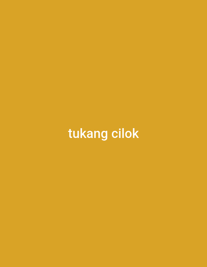 The image displays the words "tukang cilok" in white text against a solid mustard-yellow background. The text is centered horizontally and appears in the lower middle portion of the image. There are no other visible objects, people, or environmental details. This phrase, "tukang cilok," translates to "cilok seller" in English. Cilok is a type of Indonesian meatball snack. A "tukang cilok" would be a street vendor selling this snack, often found in busy public areas, markets, or on sidewalks. While the image itself does not depict a specific location, the presence of this text suggests a context related to street food culture in Indonesia, including in cities like Bogor.
