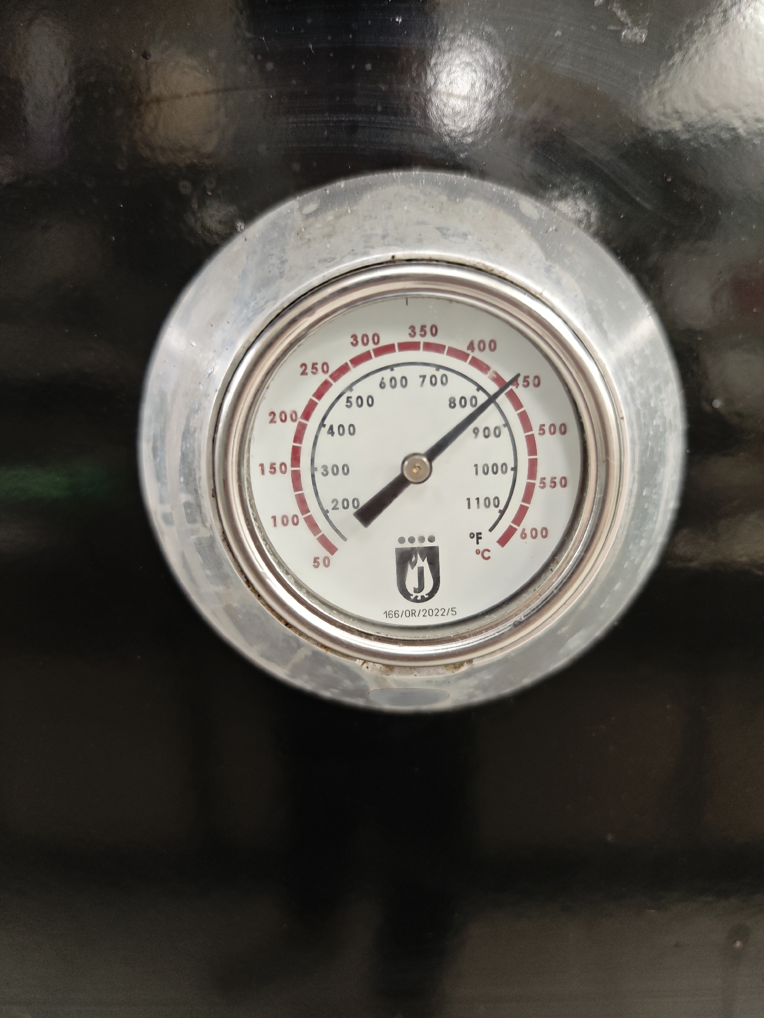 The image shows a close-up of a thermometer. The thermometer has a round face with both Fahrenheit and Celsius scales. The needle indicates a temperature of approximately 425 degrees Fahrenheit or 220 degrees Celsius. The thermometer is mounted on a black surface. The image does not provide any information about the location in Sofia, Bulgaria or any other details about people, subjects, objects, actions, interactions, or the environment.