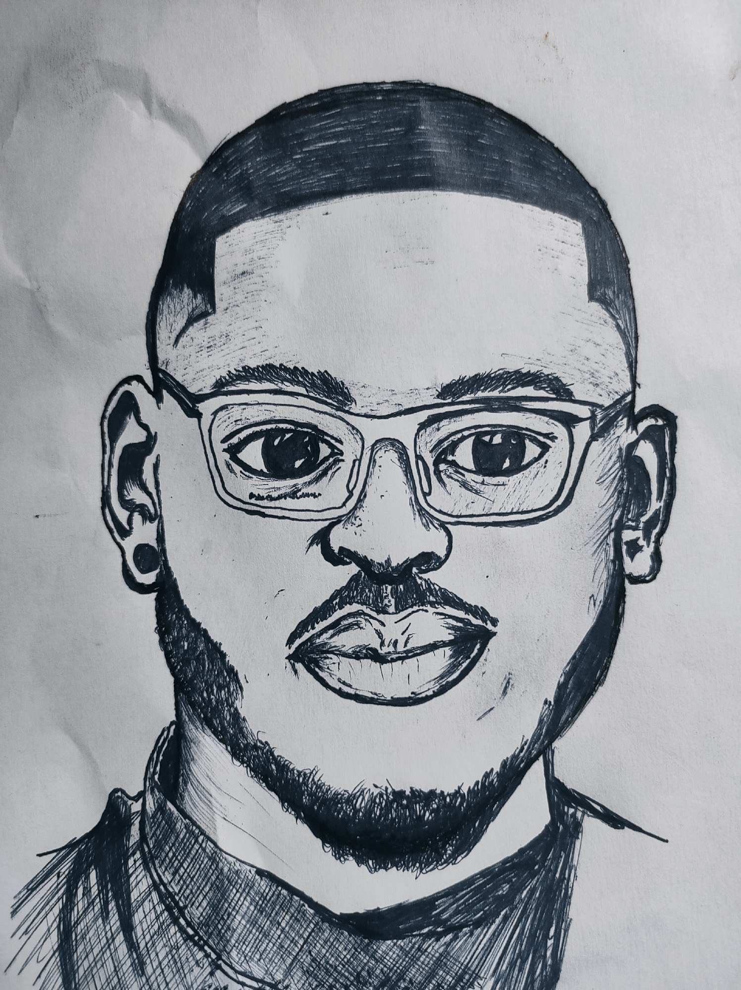 A black and white pen-and-ink portrait of a man with dark hair, a neatly trimmed beard, and glasses. He has a short haircut with a defined hairline and wears a collared shirt. The style is reminiscent of a sketch, with visible pen strokes used to create shading and texture. The background is blank, and there is no indication of location (Abuja, Nigeria) or setting within the image itself.