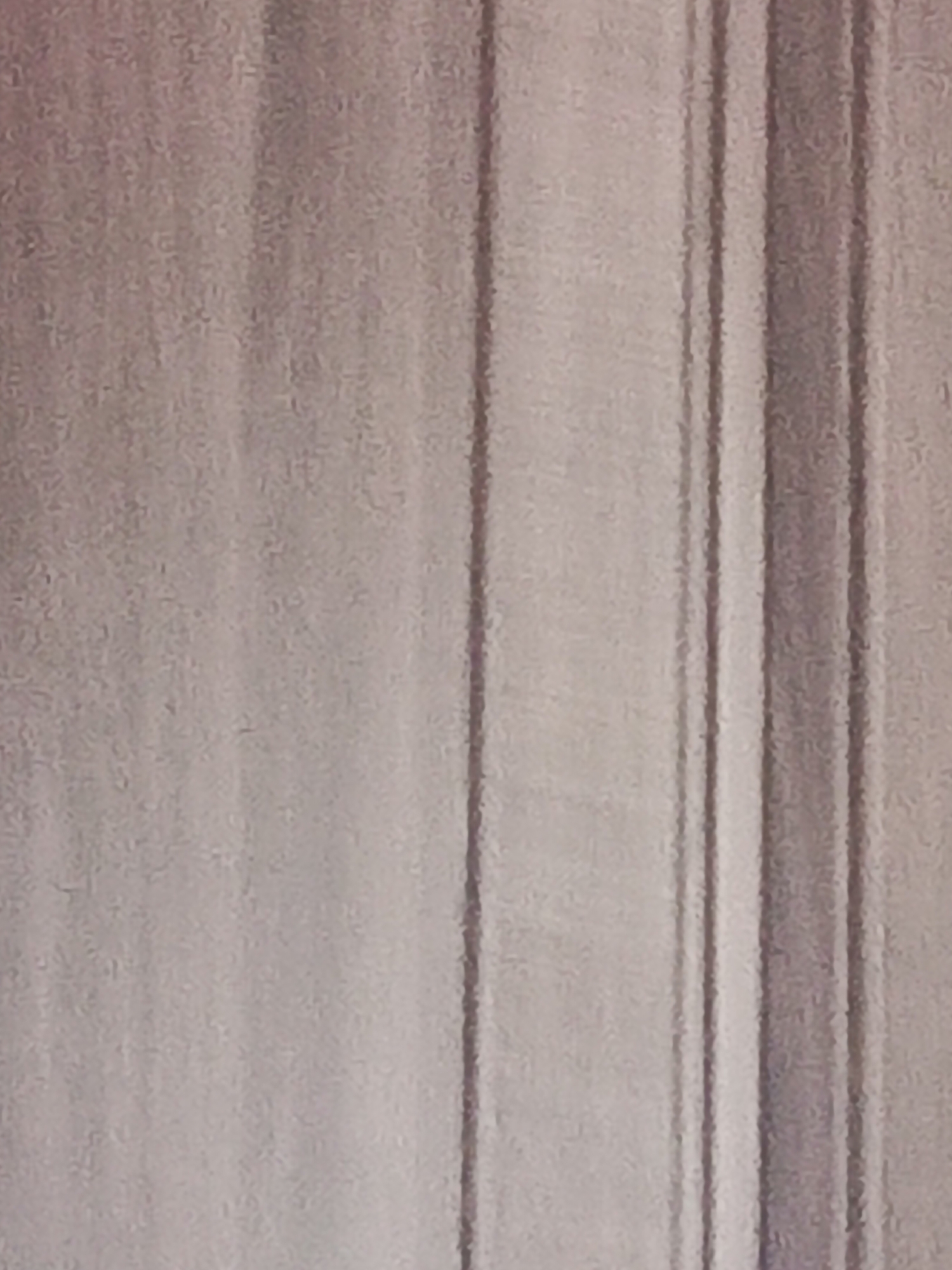 The image shows a close-up of a light-colored wall or surface with vertical patterns or lines running across it. The surface appears textured, and the lines have varying widths and depths. There are no people, subjects, or objects other than the wall/surface in the frame. The location is unspecified.