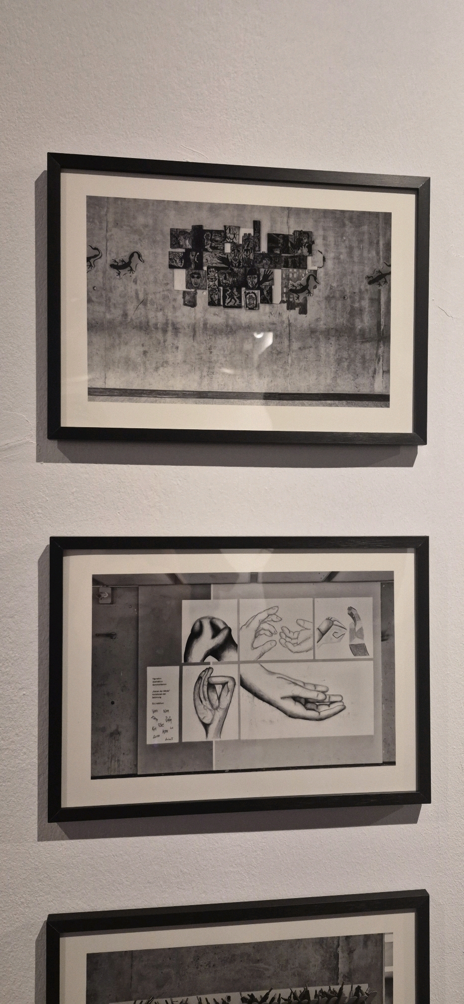 The image shows three framed artworks hanging on a textured white wall. The top artwork is a horizontal black and white photograph featuring a collage of small images arranged on a textured surface, with two silhouette figures of lizards on the left side. The middle artwork is also a horizontal black and white photograph, divided into several panels. One panel shows a close-up of a hand, and other panels contain sketches of hands in various positions, as well as some handwritten text. The bottom artwork is partially visible and appears to be a horizontal black and white photograph. The lighting suggests an indoor setting, possibly a gallery or exhibition space in Ingolstadt, Germany.