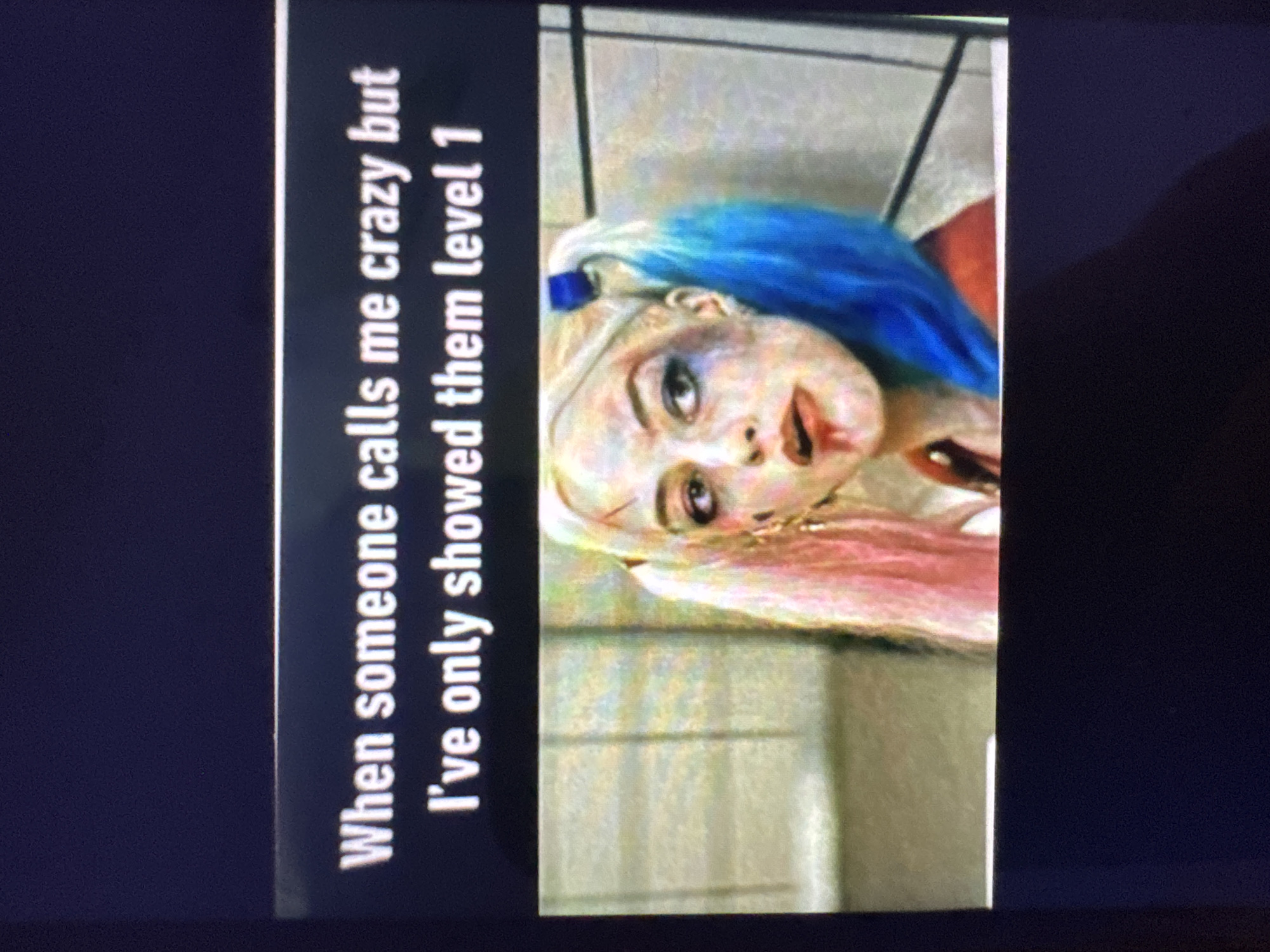 The image is a screenshot of a meme featuring a still from a movie. The meme's text, displayed in white sans-serif font against a dark background, reads: "When someone calls me crazy but I've only showed them level 1". Below the text is a close-up of a woman with blonde hair streaked with pink and blue, styled in pigtails. She has smudged makeup and a bloody lip. The background appears to be a blurred interior scene with vertical lines. There is no information within the image or its context that links it to Plovdiv, Bulgaria.