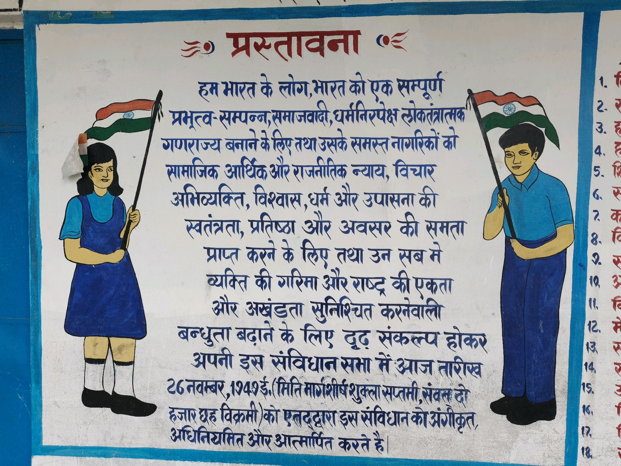This image depicts a mural on an exterior wall, likely in Katihar, India, as indicated by the use of Hindi text and the imagery. The mural features two children, a boy and a girl, standing on either side of the text, each holding an Indian flag. The text is a preamble written in Hindi, beginning with "प्रस्तावना" (Preamble) at the top. The preamble is a declaration of principles for the Republic of India, emphasizing sovereignty, socialism, secularism, democracy, justice, liberty, equality, and fraternity.
The girl on the left is dressed in a blue uniform with a white collar and is holding an Indian flag. The boy on the right is wearing a blue shirt and dark blue pants, also holding an Indian flag. The flags are depicted with the tricolor of saffron, white, and green, and the Ashoka Chakra in the center.
To the right of the main text and the boy, there is a vertical list of numbered items, also in Hindi. These numbers range from 1 to 18, suggesting a list of rights or principles. The wall itself appears to be made of concrete and painted white, with blue borders at the top and bottom. The mural is colorful and appears to be a public artwork, possibly located near a school or government building.