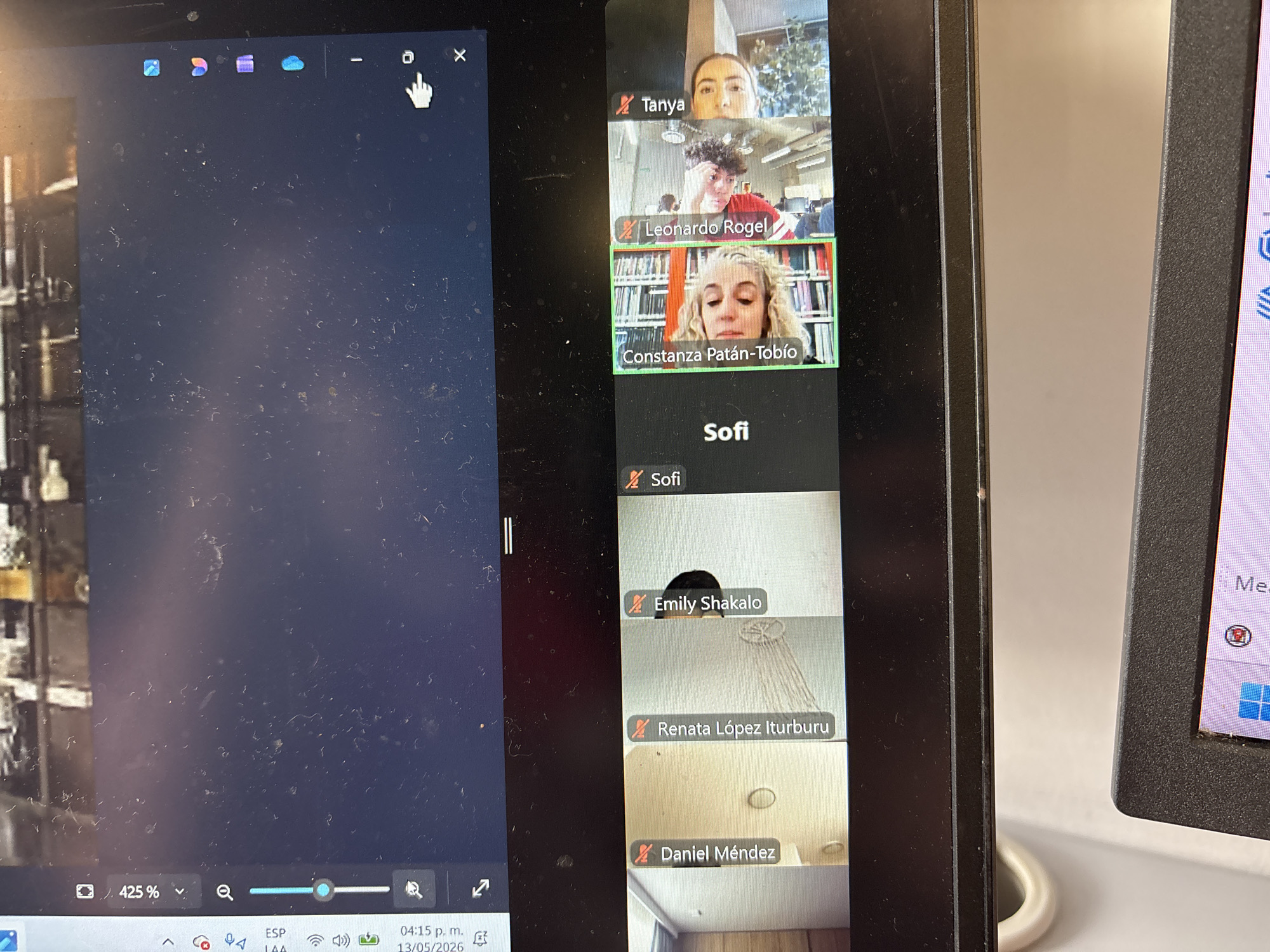 The image shows two computer screens displaying a Zoom meeting. The left screen shows a blurred image and a zoom setting of 425%. The bottom corner shows the date and time as 04:15 p.m. on May 13, 2026. The right screen displays several participants in the Zoom meeting. The participants listed are Tanya, Leonardo Rogel, Constanza Patán-Tobío, Sofi, Emily Shakalo, Renata López Iturburu, and Daniel Méndez.