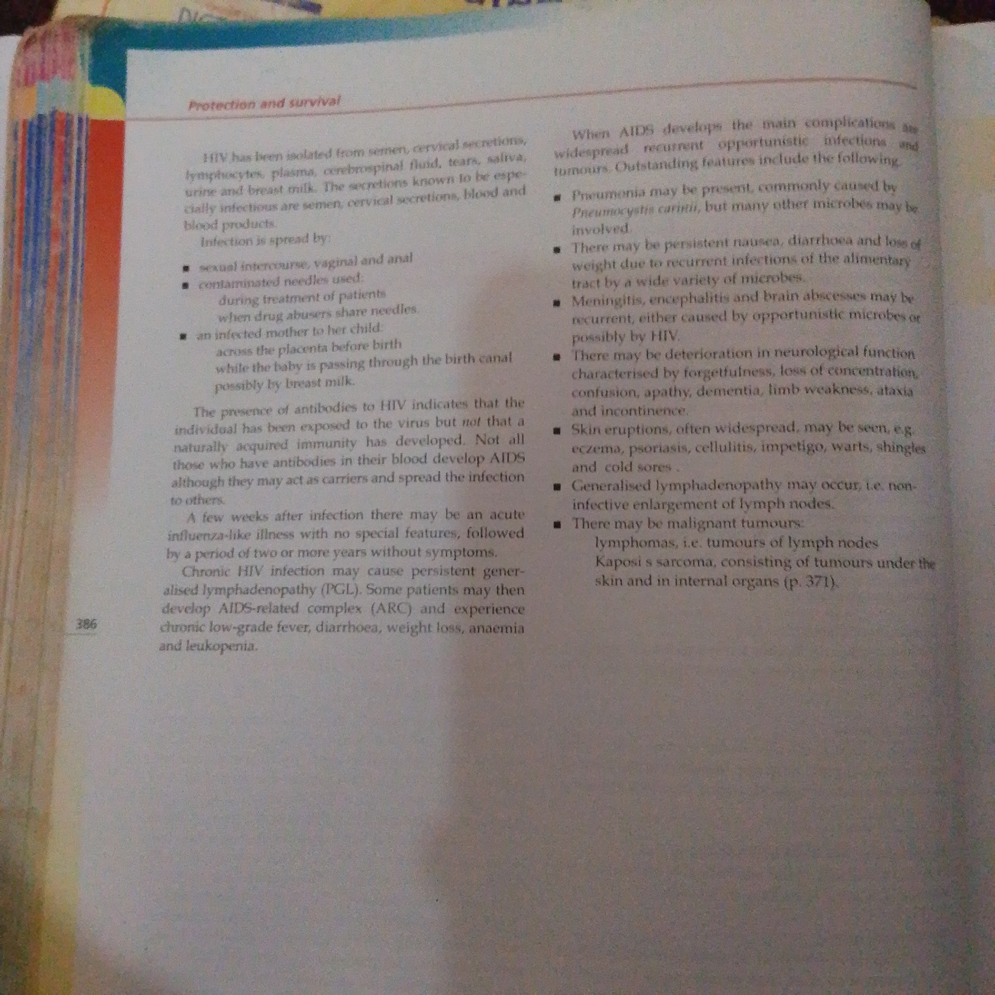 The image shows a page from a book with text about HIV and AIDS. The text is divided into two columns. The left column discusses the transmission and symptoms of HIV infection. The right column focuses on the complications that arise with AIDS. The page is slightly angled and appears to be from a textbook or educational material. There is no discernible information in the image that relates to the city of Jalingo, Nigeria.