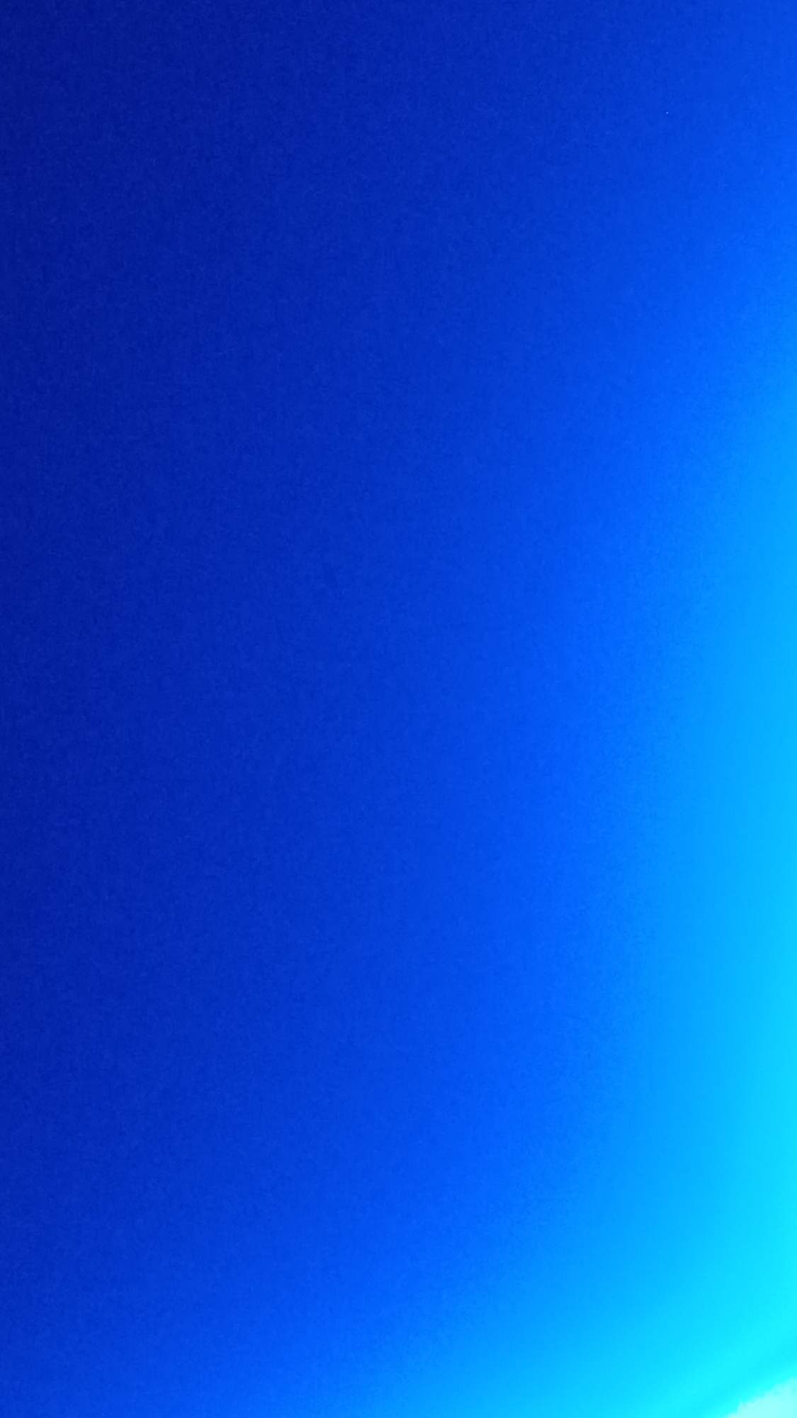 The image displays a gradient of blue, transitioning from a deep, solid blue on the left to a lighter, almost turquoise blue on the right. There are no discernible objects, people, or structures within the frame, suggesting an abstract or atmospheric scene. The context of Zvenigorod, Russia, is not visually represented in this image, as it solely captures a color gradient.