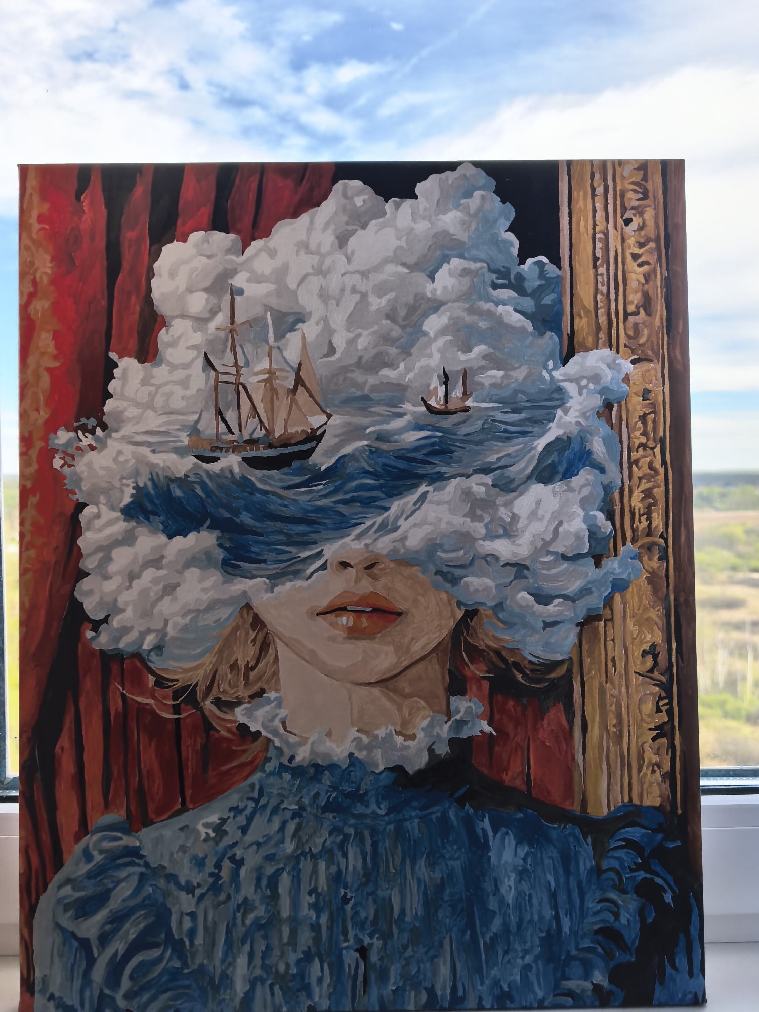 The image is a photograph of a painting. The painting depicts a woman in a blue dress. Her face is partially obscured by a swirling cloud formation containing two sailing ships amidst stylized blue waves. The woman's lips are visible.
The painting is set against a backdrop of red curtains on the left and a gold ornate picture frame element on the right.
The photograph is taken indoors, next to a window. The out-of-focus view through the window shows a blue sky with clouds and a distant landscape, which is not specifically identifiable as Yekaterinburg, Russia. The painting is not visibly located in Yekaterinburg, Russia within the picture.