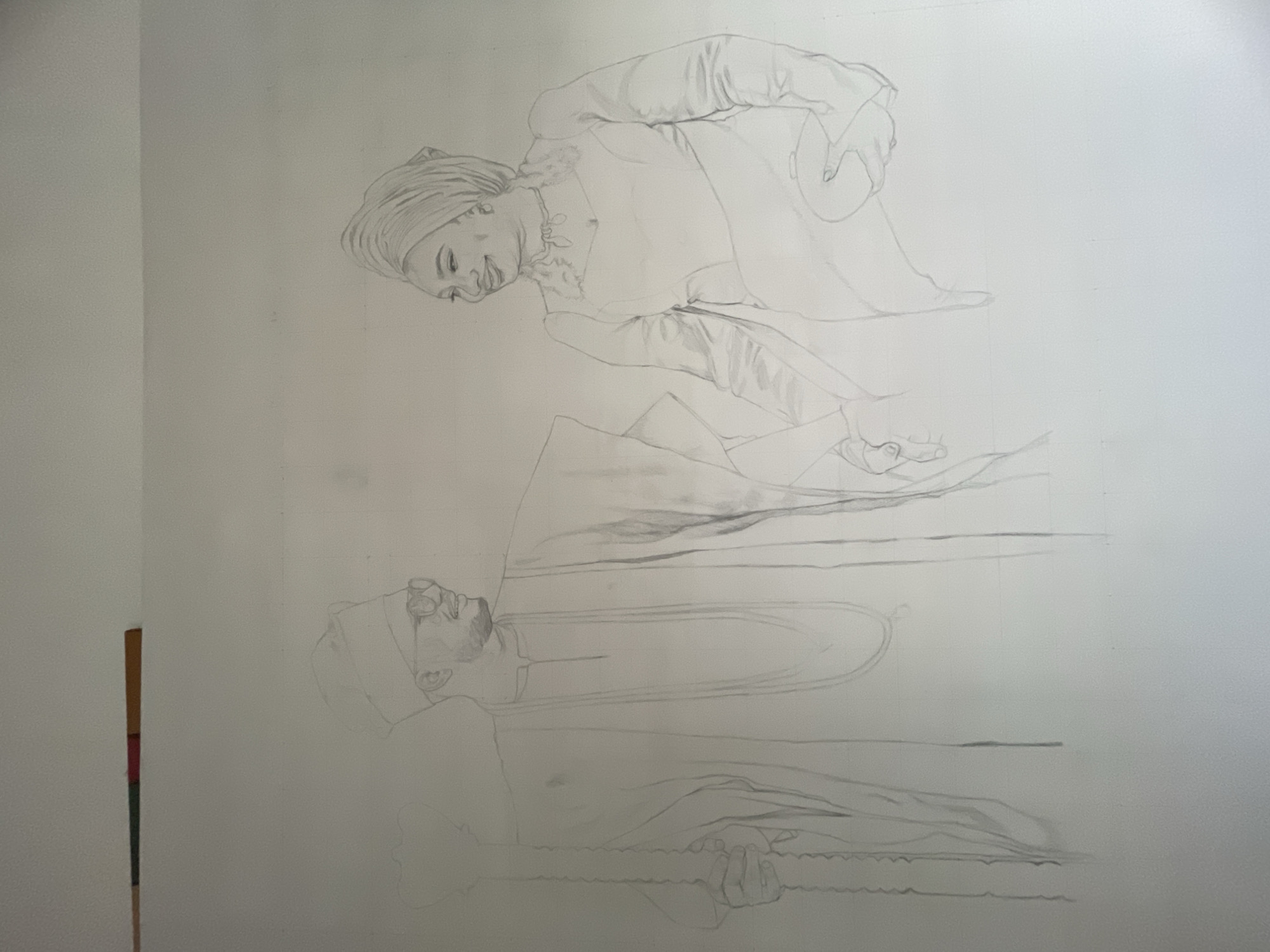 A pencil sketch on a large sheet of paper. A woman is depicted at the top, wearing a head covering and holding an object. Below her is a man wearing glasses, lying down and holding a long, thin object. The background is plain white.