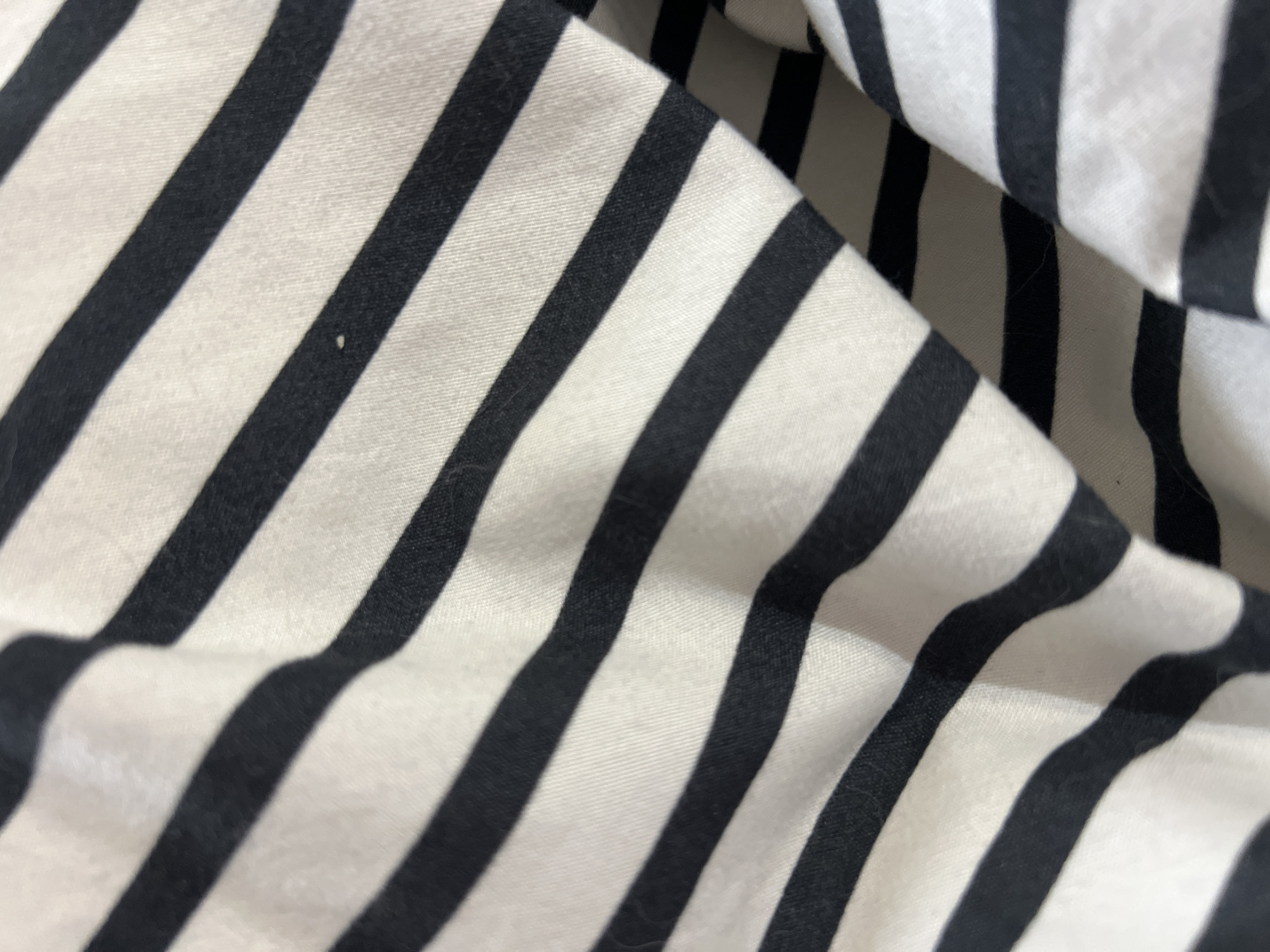 The image depicts a close-up of a striped black and white fabric. The fabric is folded and wrinkled, creating variations in light and shadow. The location and specific details about Gradishte, Bulgaria are not discernable from the image.