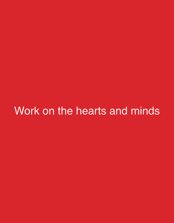 The image is a plain red background with white text that reads "Work on the hearts and minds". The text is centered horizontally and positioned in the lower half of the image. There are no people, objects, or any indication of a specific location in New Stadium, Nigeria. The image appears to be a graphic or a quote with a solid color background.