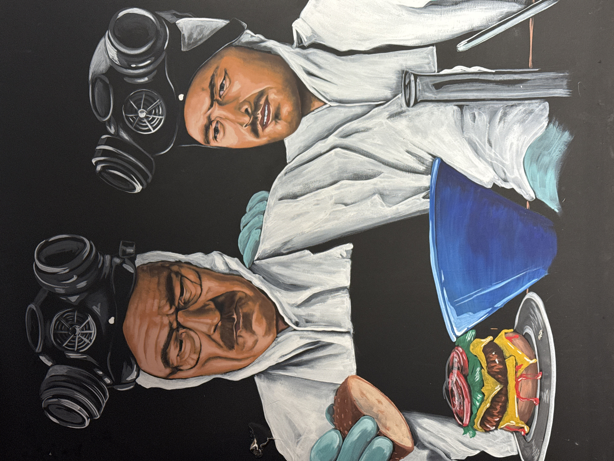 Two people, each wearing a white lab coat and a gas mask, are depicted in a painting against a black background. The first person, located at the top of the image, has a test tube. The second person is located at the bottom and is holding a burger. The lower right part of the painting contains a plate with a burger on it.
This image does not suggest it comes from Boreti, Montenegro.