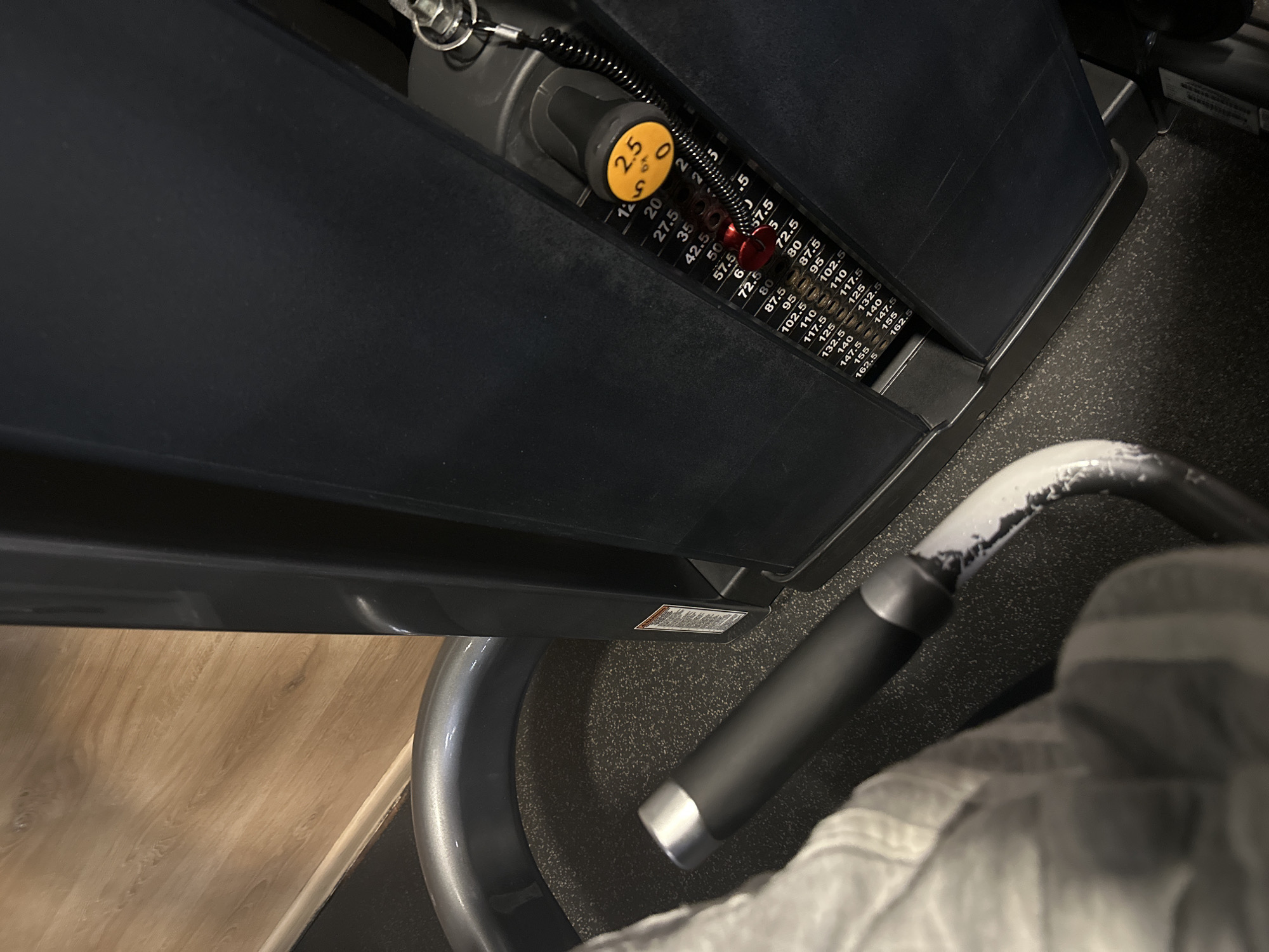 This image shows a close-up of a weight selection mechanism on a gym machine. The dial is set to 2.5, and the weight values are indicated on a graduated scale, ranging up to 162.5. The machine is black. A gray handle with a black grip is also visible. The flooring is both wood and rubber. The location and city of Plovdiv, Bulgaria, cannot be determined from the image.