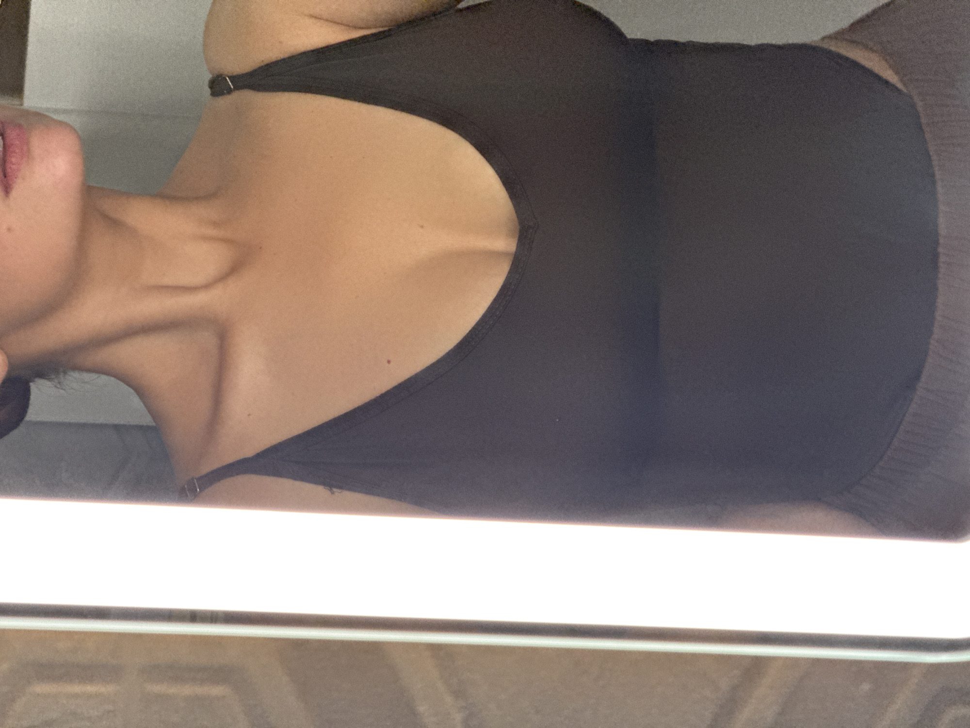 The image shows a person from the chest up. The person is wearing a black tank top and light-colored pants. The person is inside, and the image is taken from a low angle. No information indicates the location is Chaikovsky, Russia.