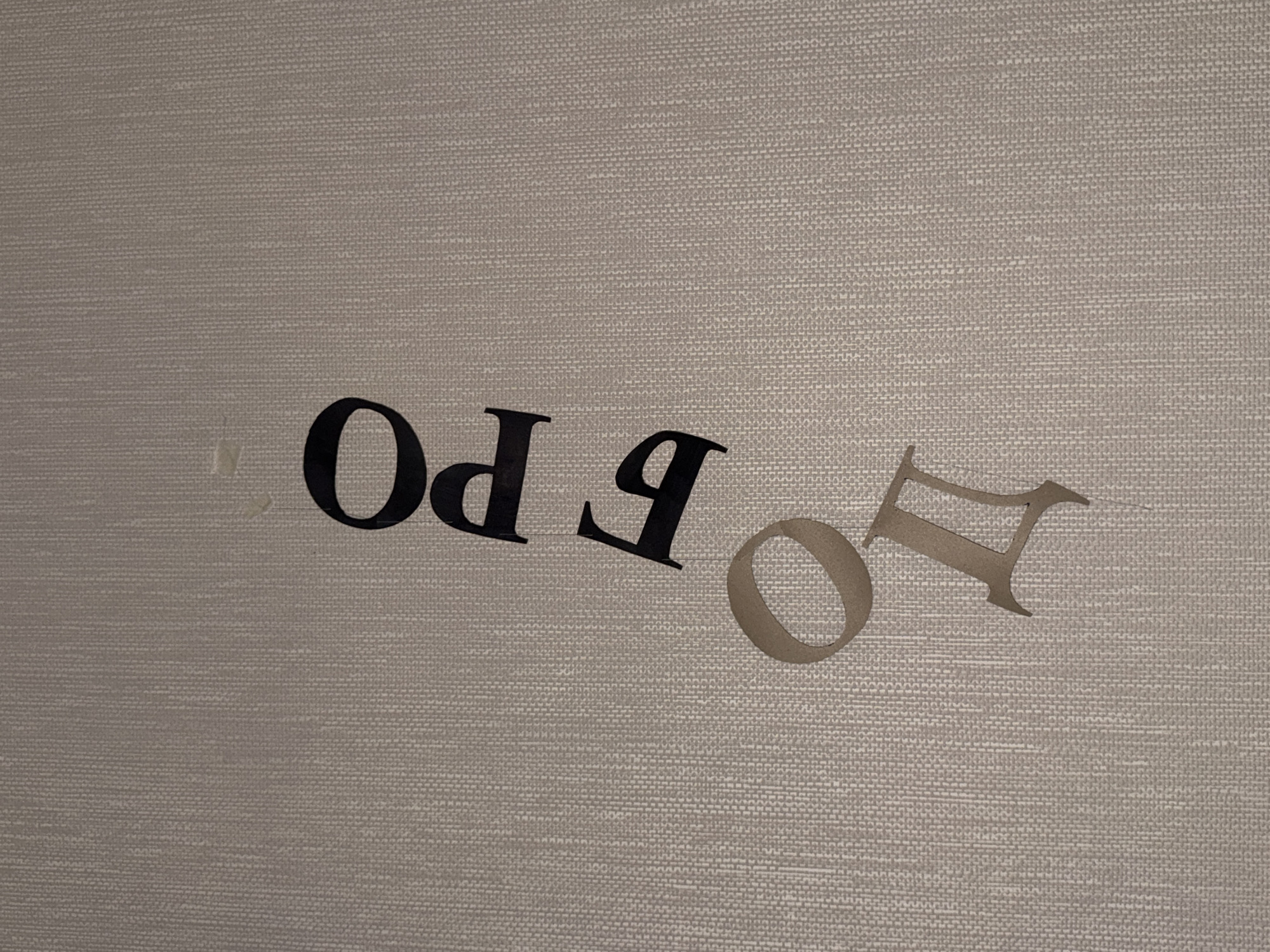 The image shows the letters "FRO" in black, and the letter "д" in beige, against a textured, light brown background. The letters appear to be cut out and placed on the background, possibly as part of a decorative display or signage. There is no discernible location in the city of Perm, Russia mentioned or implied within the image itself. The image is a close-up of the letters and background, with no other objects or people present.