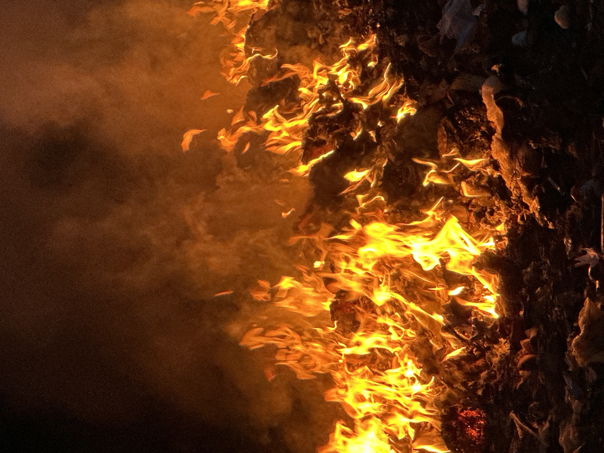 The image shows a large fire with thick smoke billowing on the left side. Flames engulf debris on the right, with a dark, undefined area beyond the fire. The exact location in Bac Nha Trang Ward, Vietnam, is not discernable without additional context. There are no people visible in the image. The scene is dominated by fire and smoke.