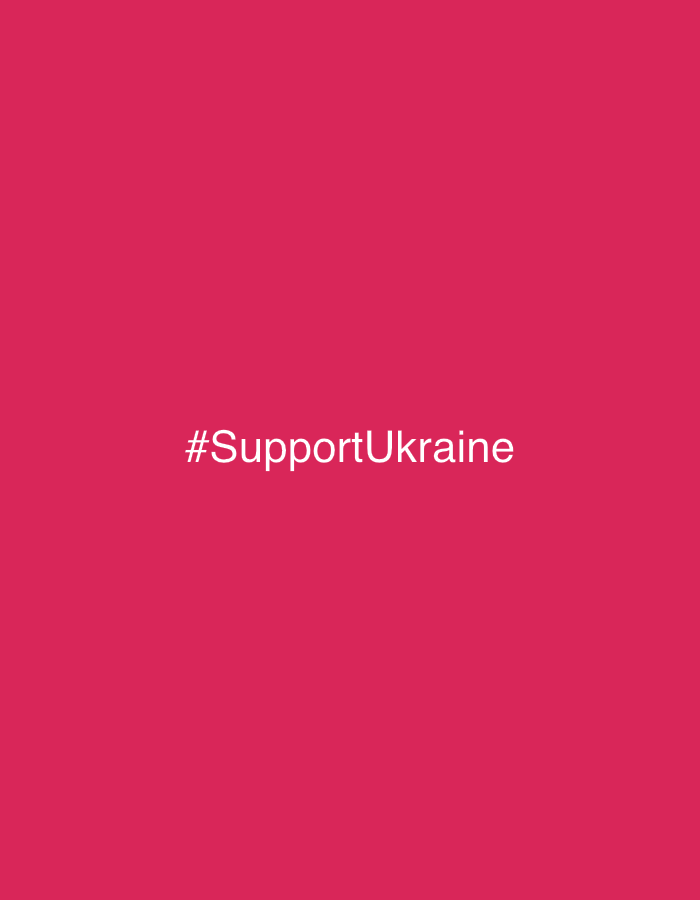 A vibrant, solid reddish-pink background dominates the image. Centered horizontally and vertically is the text "#SupportUkraine" in white, crisp font. The color contrast ensures high visibility, creating a simple yet impactful message of solidarity.