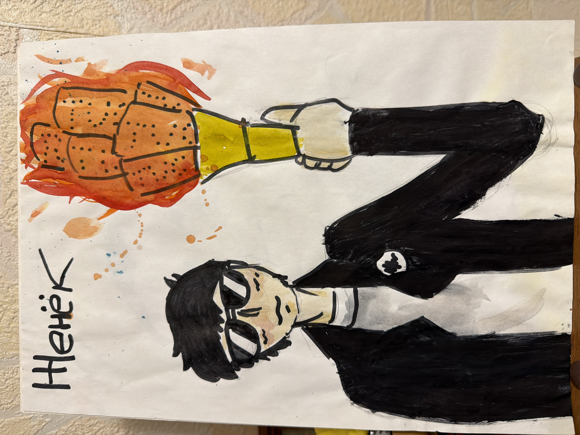 A hand-drawn, color image on white paper depicts a man holding a Molotov cocktail. The man has black hair, sunglasses, and wears a black suit with a white collar. He is holding a lit Molotov cocktail in his right hand. The Molotov cocktail has an orange, flammable substance and a yellow neck. The word "Hehek" is written in black marker to the left of the man. No location information is discernible from the image.