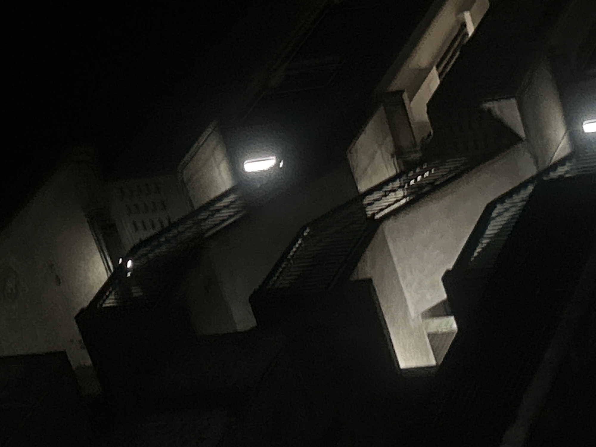 The image shows an outdoor staircase at night. It appears to be a fire escape or secondary staircase attached to a building. The staircase has metal railings and concrete or stone steps and landings. There are lights illuminating the staircase. The location is likely in an urban area, and the buildings are of a relatively modern style. However, based solely on the image, the exact location within the city of London, United Kingdom, is impossible to determine.
