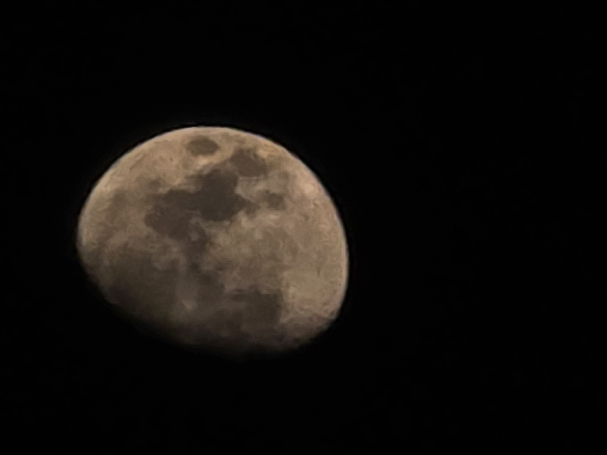 The image displays a close-up view of the moon against a black, starless sky. The moon is partially illuminated, with a crescent shape visible. The surface of the moon shows textured details, including craters and darker maria. The lighting suggests it is night. There is no indication of the city of Yambol, Bulgaria, in this image.