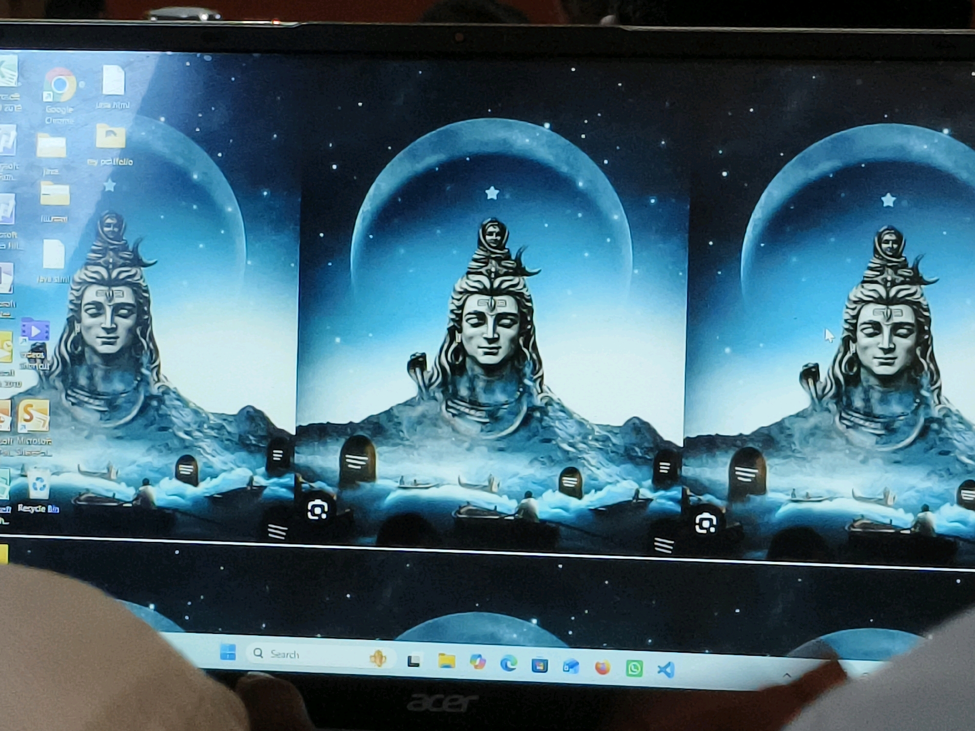 The image shows a computer screen displaying a digital artwork of Lord Shiva, repeated three times across the screen. The artwork depicts Shiva's head and upper torso against a backdrop of a large moon and a starry sky. In the foreground, there are small boats on a body of water, with figures rowing them and what appear to be tombstones. The bottom of the screen shows a Windows taskbar with icons for various applications, including a search bar. The reflection of a person's hand is visible in the lower part of the screen. There is no discernible connection to the city of Faridpur, India, in the image.