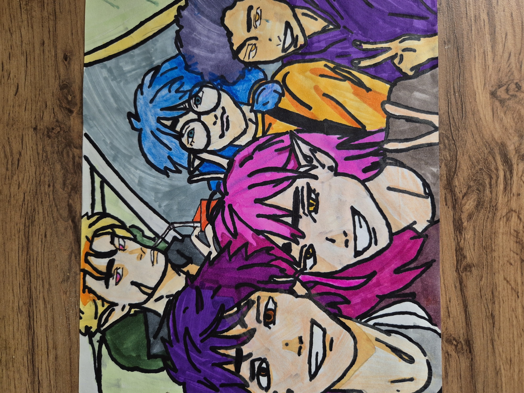 The image is an eye-level, medium close-up shot of a drawing depicting five characters with vibrantly colored hair: purple, blue, pink, purple, and blonde. The subjects are closely stacked together, faces angled upwards towards the viewer. The character with blue hair wears round glasses. The character with purple hair towards the top of the image is making a peace sign. The background features abstract gray and green shapes. The drawing is positioned on a wooden surface with a light brown hue. The location is Unknown, Unknown.