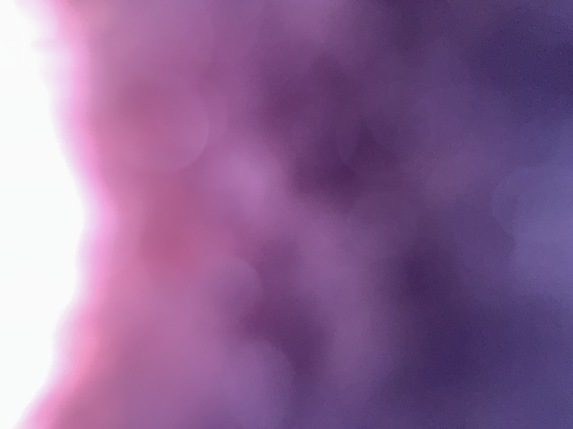 This is an abstract, out-of-focus image with a gradient of colors. The top of the image is bright white, transitioning into soft pink and then deepening into shades of purple and violet towards the bottom. There are soft, circular bokeh effects scattered throughout the image, particularly in the middle section. The texture appears slightly grainy or textured, giving it a painterly or diffused quality. There are no discernible people, objects, or identifiable locations within the image. The image does not depict any scene in Belgrade, Serbia, or any other specific geographic location.
