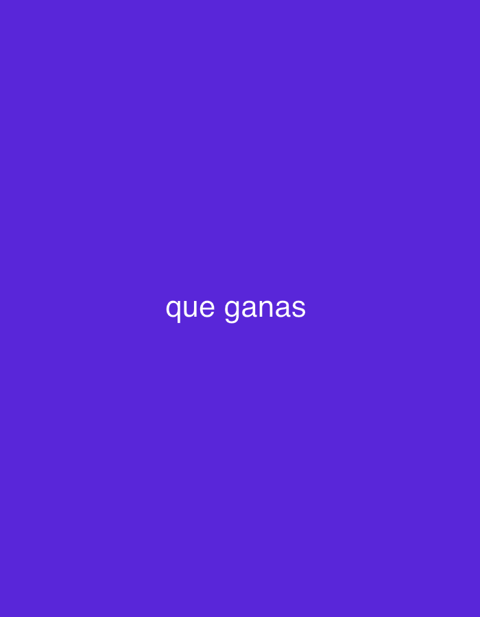 The image features a solid, plain purple-blue background. Centered on this background, the Spanish phrase "que ganas" is displayed in white, sans-serif capital letters. No people or objects are visible in the image. There is no depicted activity or event. The scene is devoid of specific location cues, weather, or time of day, beyond the provided context of Santa Ana, Venezuela, which is not visually represented. The text "que ganas" translates to "what desire" or "how much I want/feel like," conveying a sense of longing or enthusiasm.