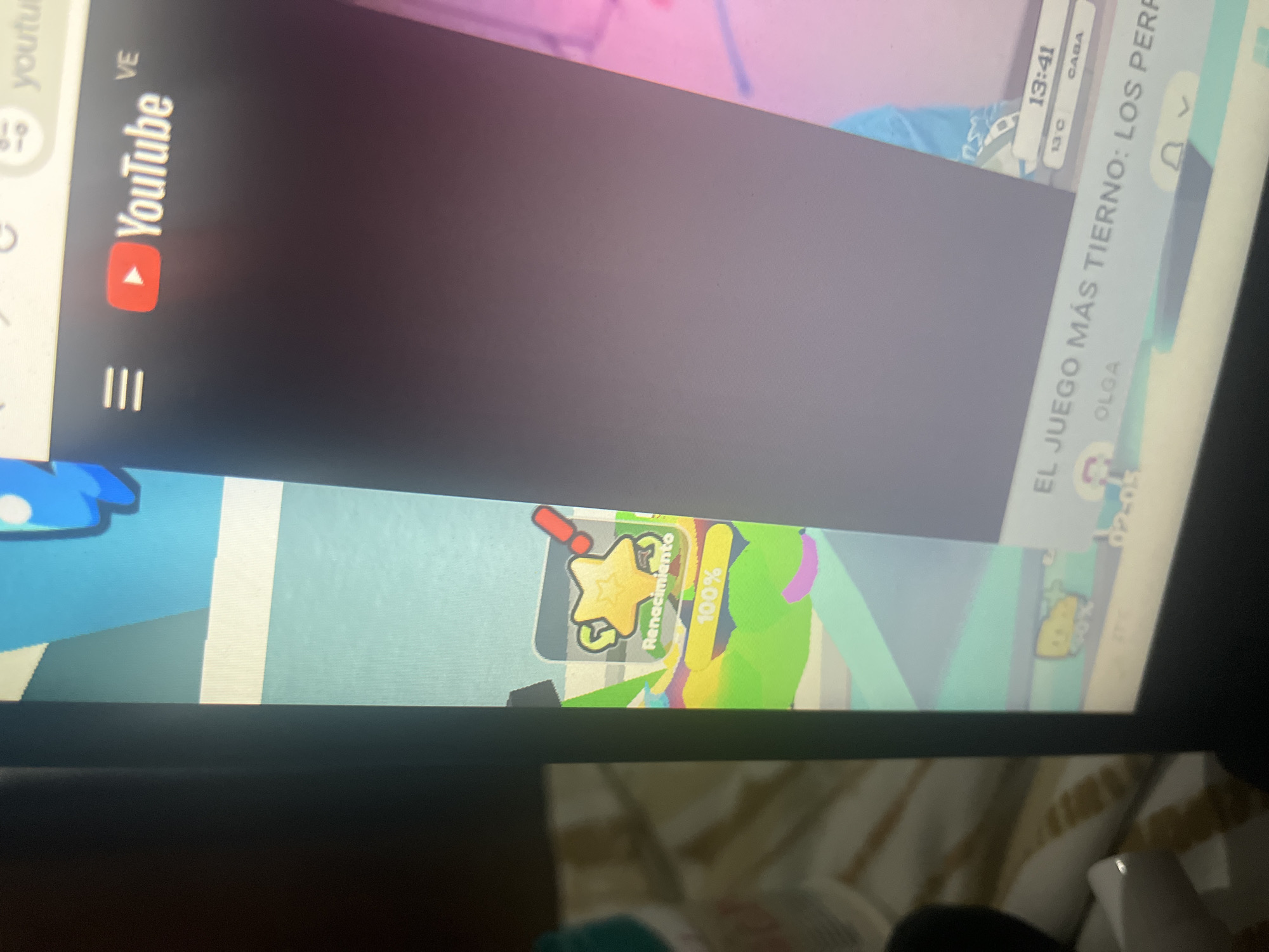 The image shows a computer screen displaying a YouTube video. The video appears to be a gameplay stream, with a game interface visible on the left side of the screen featuring a star icon, the word "Renacimiento," and "100%." The YouTube logo is also visible on the top right of the screen. The overall scene suggests a person is watching or streaming a video on their computer. The location in Santa Ana, Venezuela is not determinable from the image.