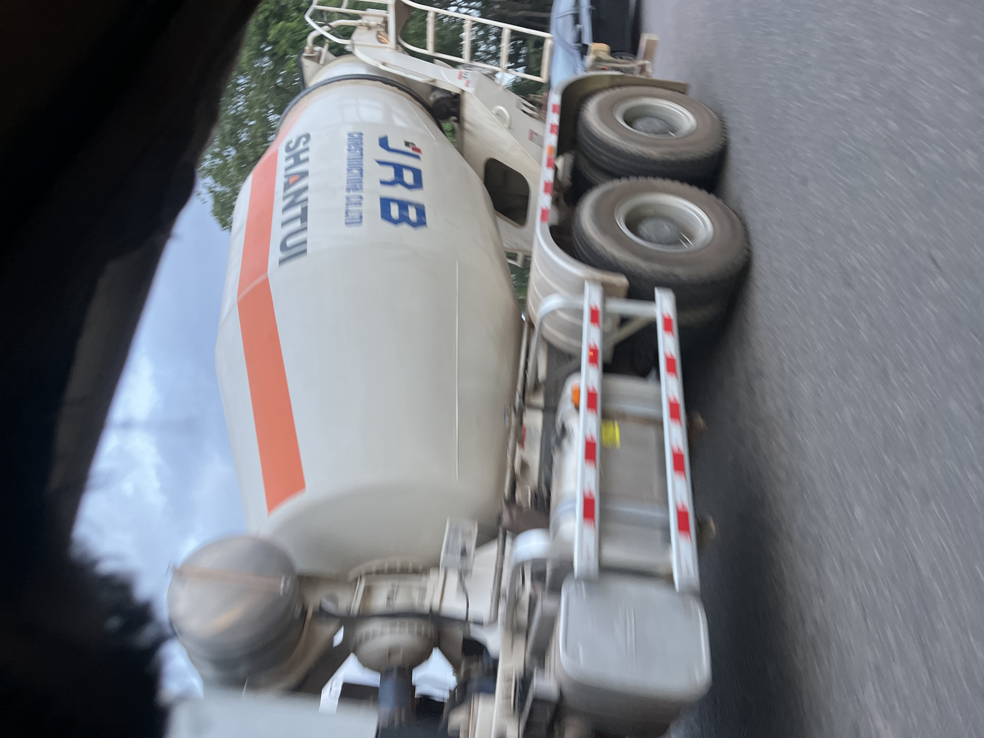 A cement mixer truck with the markings "JRB Construction Co., LTD" and "Shantui" is on a paved road. The location is unknown; no evidence of the city of Karmajiji, Nigeria is apparent in the image.