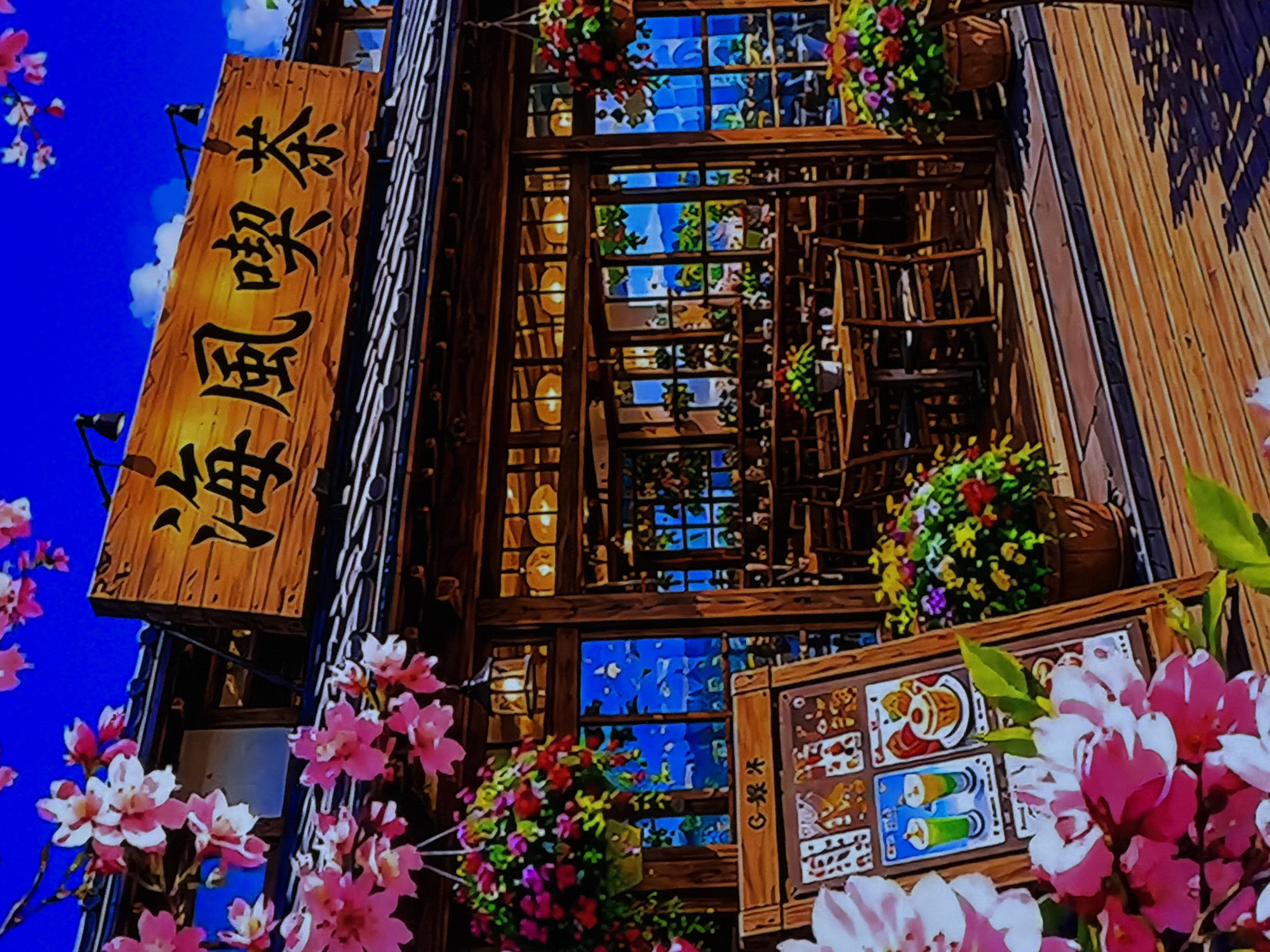 This image depicts a vibrant, anime-style illustration of a multi-story wooden building, likely a Japanese cafe or teahouse, set against a bright blue sky. The building features numerous windows with wooden frames, some showing glimpses of an interior with what appears to be seating or shelves. Hanging baskets filled with colorful flowers adorn the building's exterior, adding to its charming aesthetic.
The scene is framed by numerous pink and white cherry blossoms (sakura) in the foreground and along the left side, suggesting a springtime setting. The time of day is clearly daytime, given the bright, cloud-dotted sky.
A prominent vertical wooden sign on the left side of the building displays Japanese characters. The text reads "海風喫茶" (Kaifū Kissa), which translates to "Seabreeze Cafe" or "Seabreeze Teahouse." Below this main sign, another smaller wooden board is visible in the lower right. This board appears to be a menu, showing illustrated food and drink items, including two tall glasses with green beverages and a dessert or parfait. A small, partially visible signature or text "C・R 茶" is also present on this smaller board, with "茶" meaning "tea."
The overall impression is one of a peaceful, inviting, and picturesque establishment, likely designed to evoke a pleasant, relaxed atmosphere.