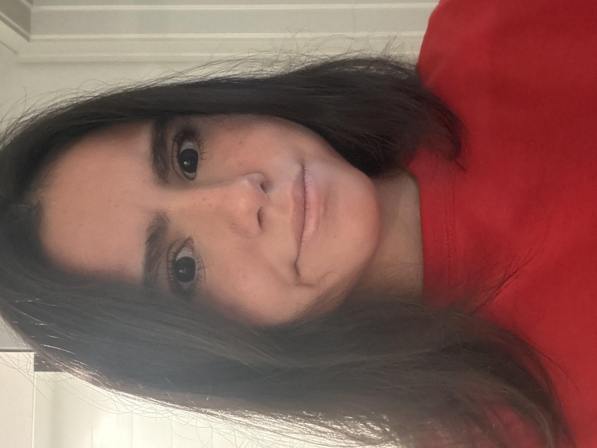 A person with dark hair and a red shirt is visible in the image. The background appears to be a wall. There is no information to determine the location of the image in Austin, United States of America.